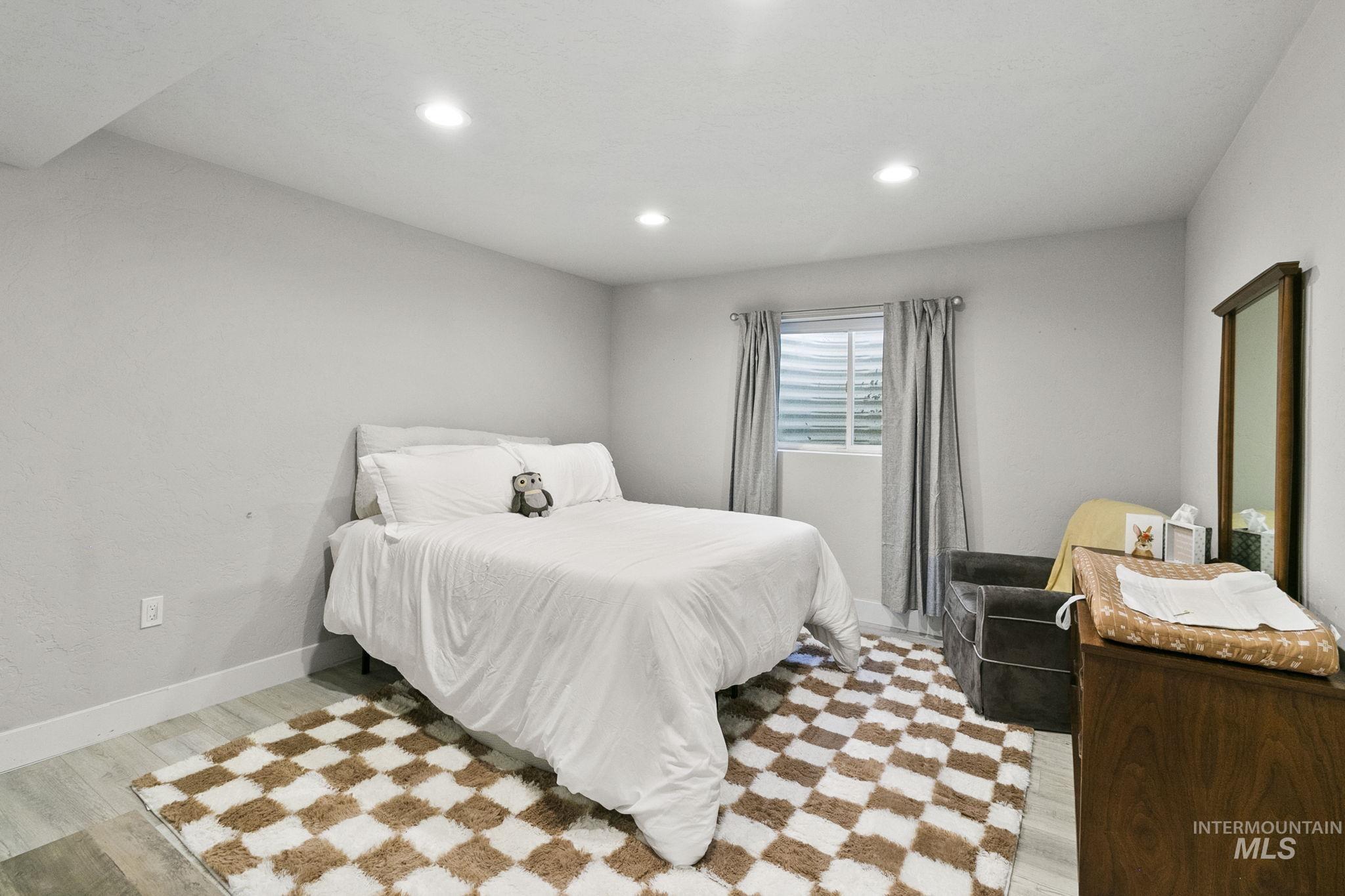 Bedroom with light wood-style floors and recessed lighting