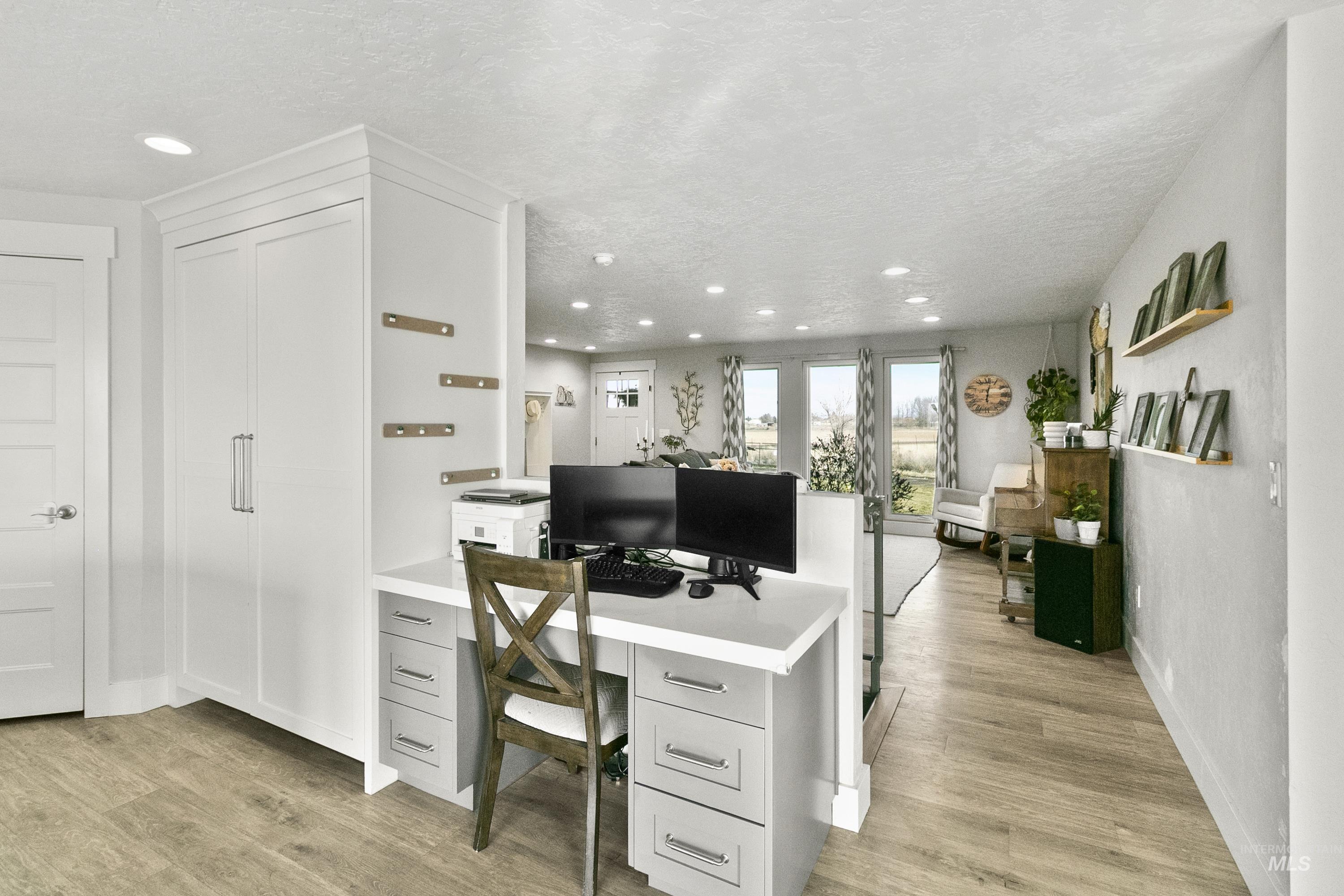 Home office featuring light wood-style flooring, a textured ceiling, and recessed lighting