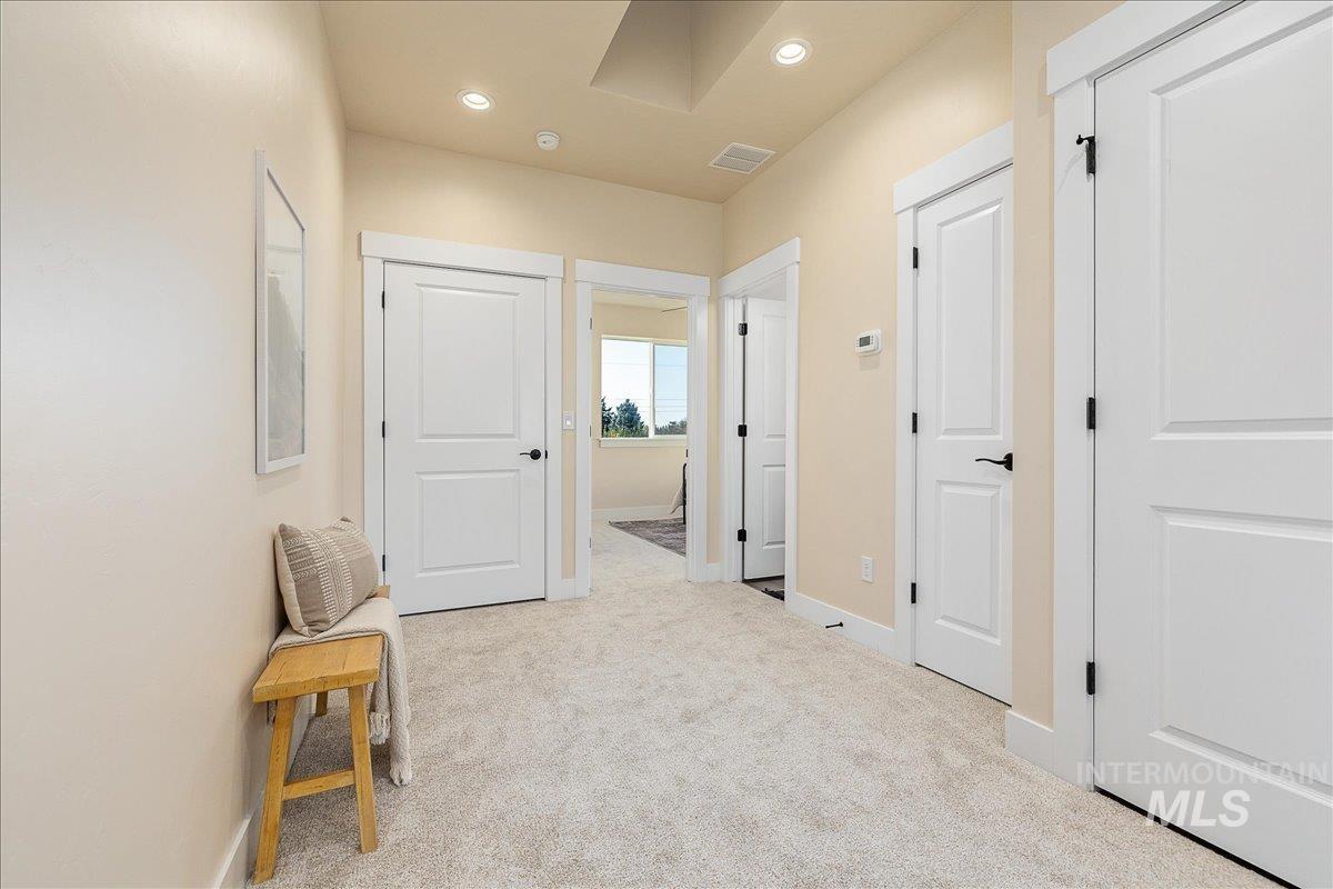 Hall featuring light carpet and recessed lighting