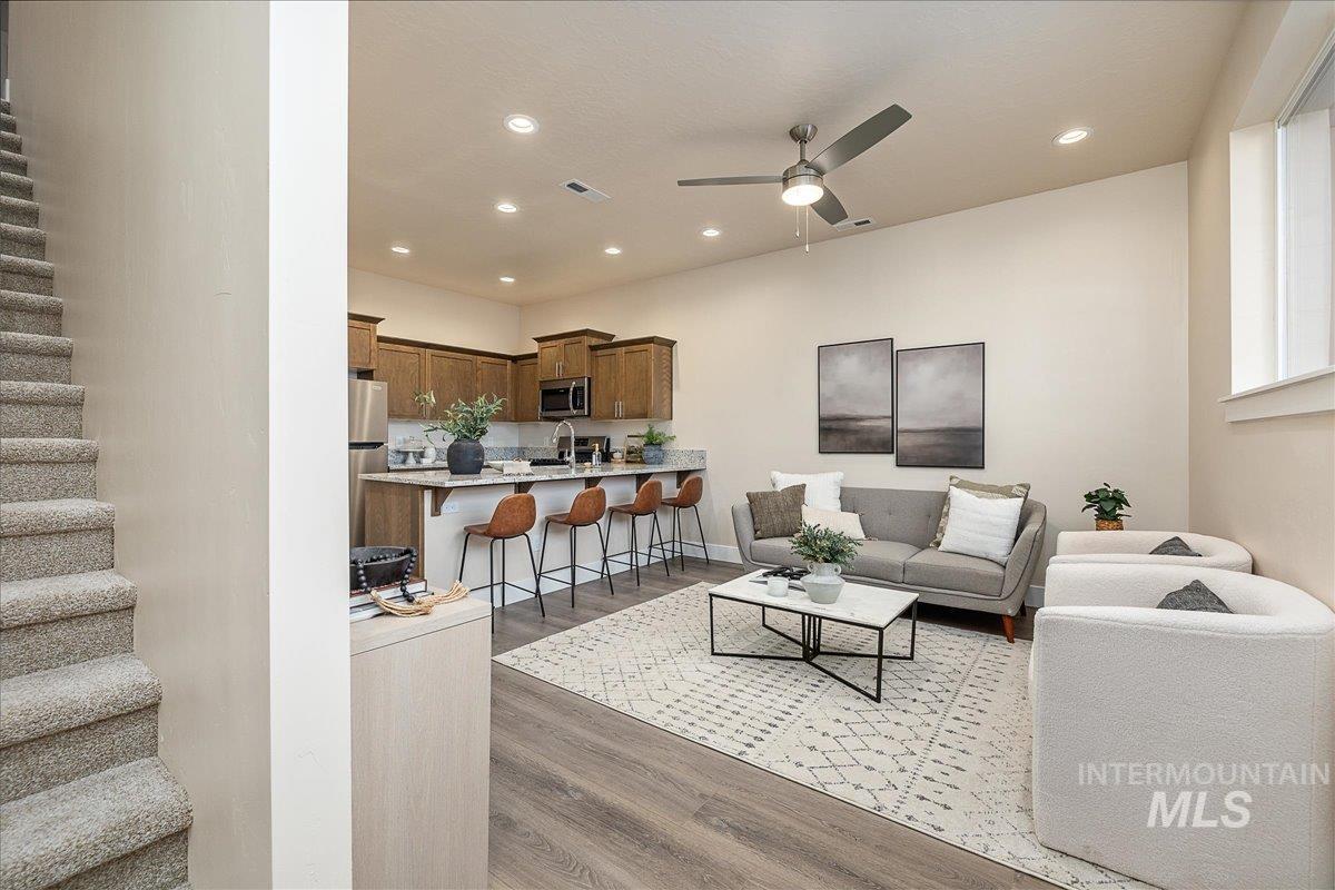 Living area with stairs, recessed lighting, dark wood-type flooring, and a ceiling fan