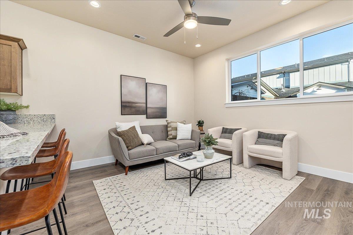 Living area with recessed lighting, light wood finished floors, and ceiling fan