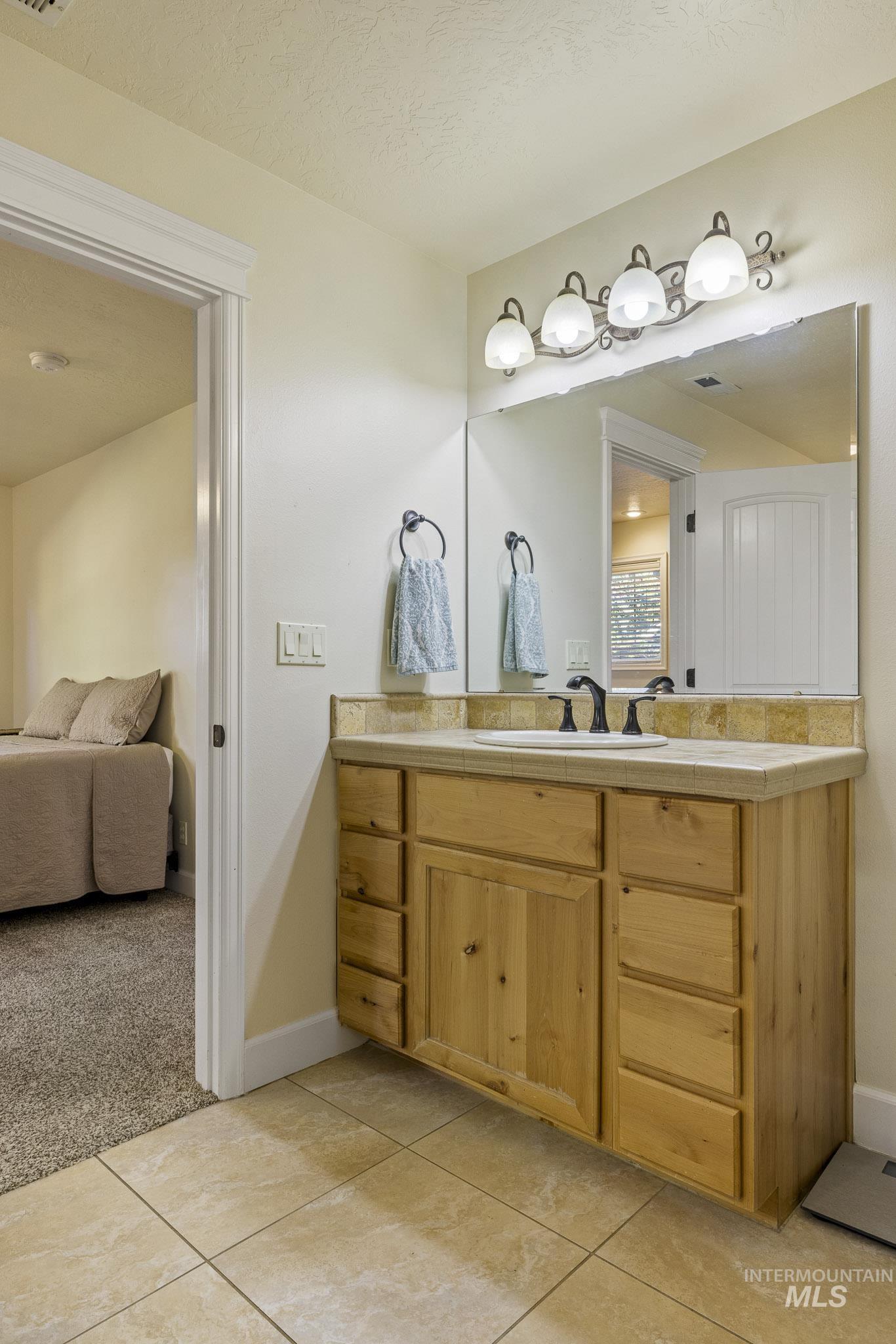 Bathroom featuring vanity, light colored carpet, and light tile patterned floors