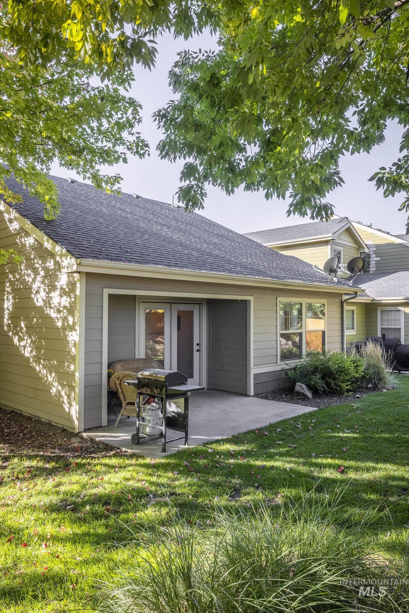 View of front of home with roof with shingles, a front yard, and a patio