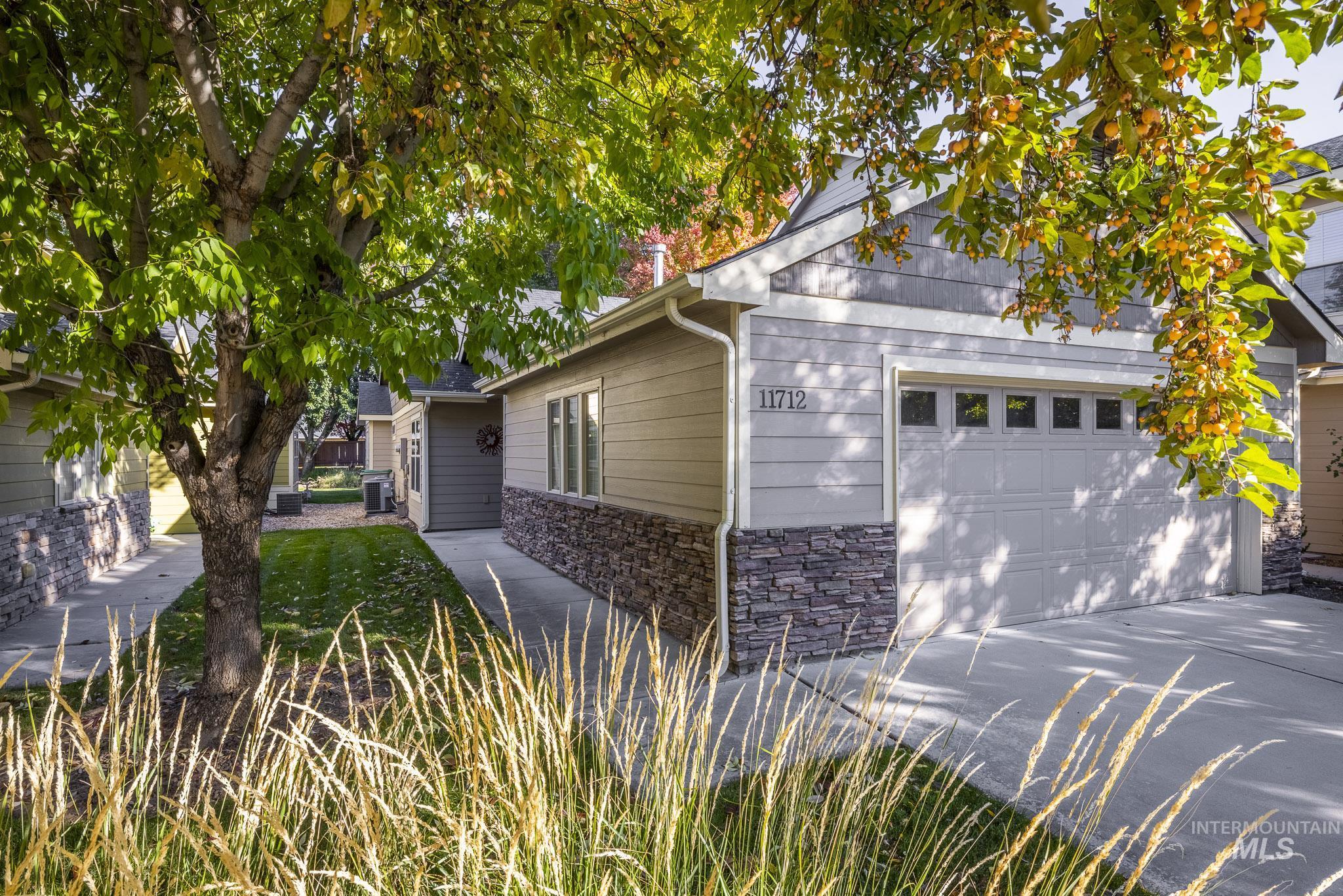 View of front of property with stone siding, a garage, and concrete driveway