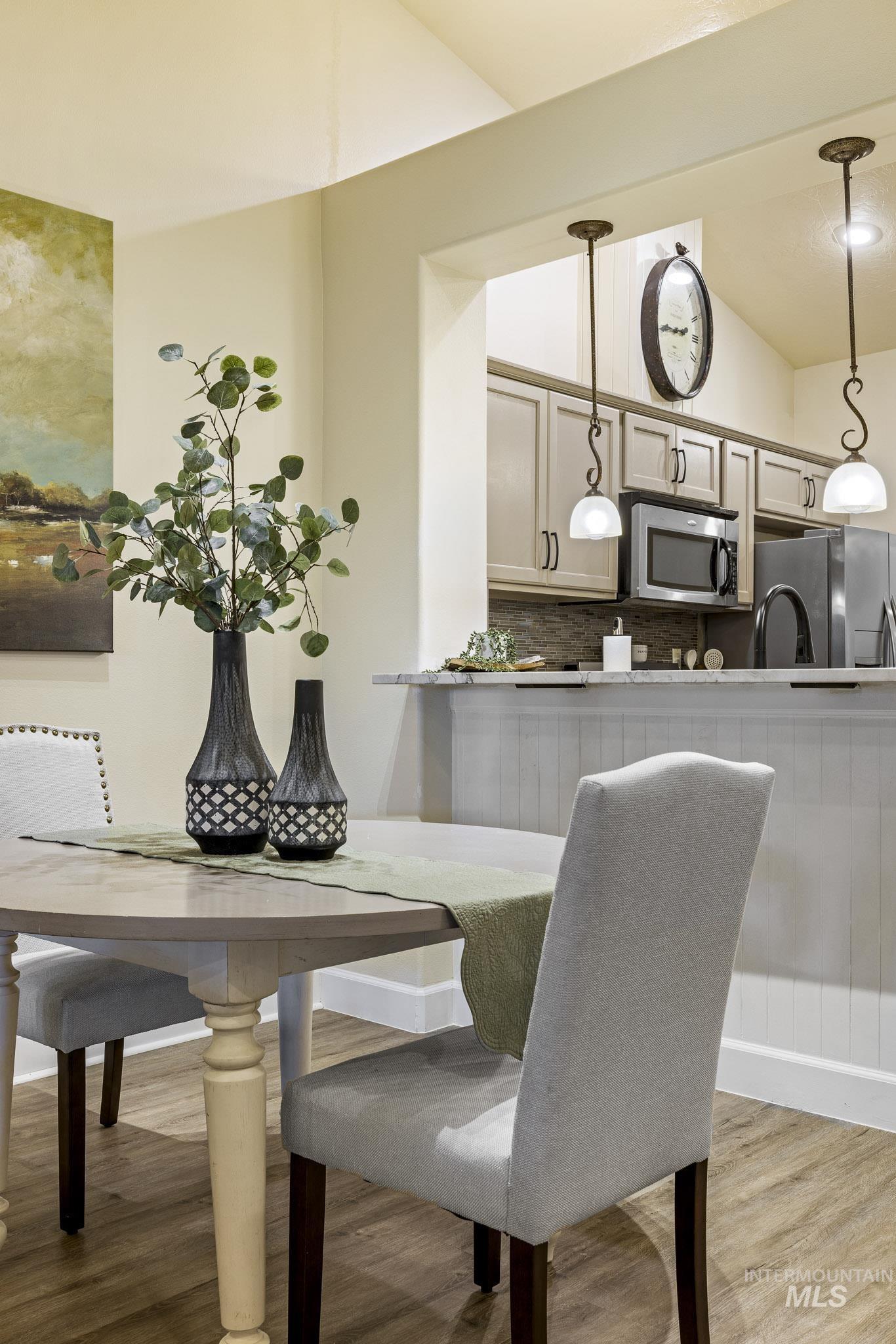 Dining area with light wood finished floors and lofted ceiling