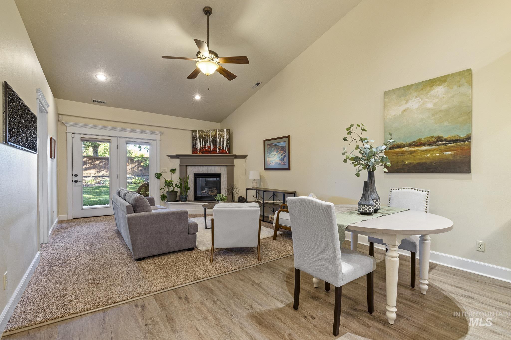 Dining room featuring high vaulted ceiling, a tile fireplace, light wood-style flooring, ceiling fan, and recessed lighting