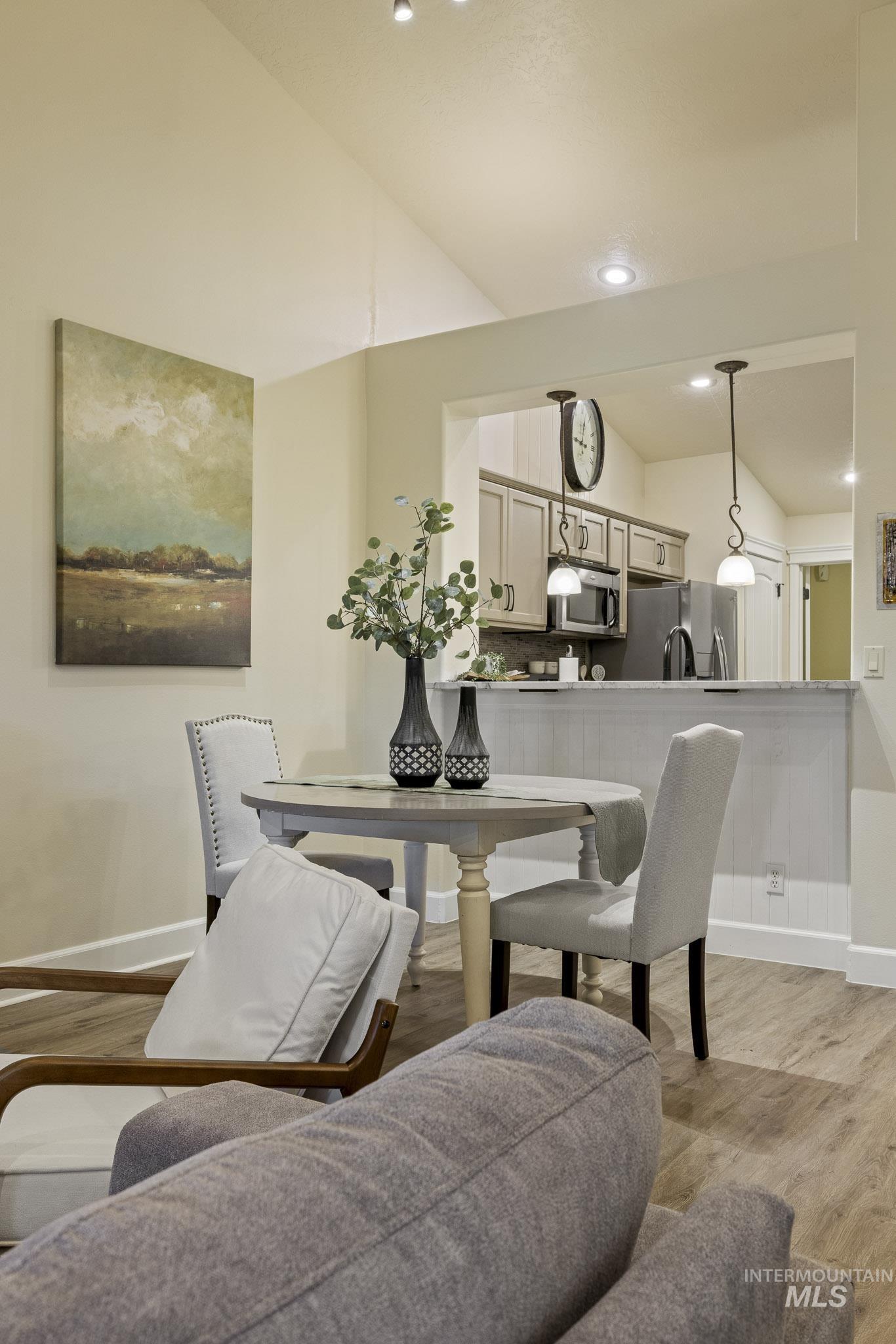 Dining area featuring lofted ceiling, light wood-type flooring, and recessed lighting