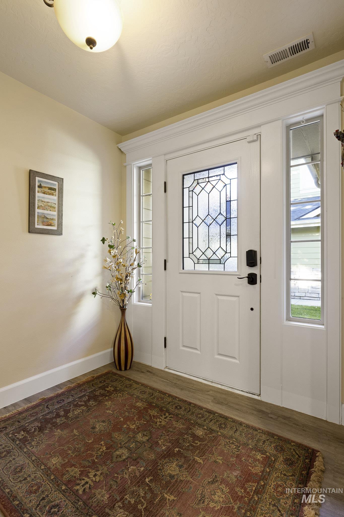 Foyer entrance featuring wood finished floors and baseboards