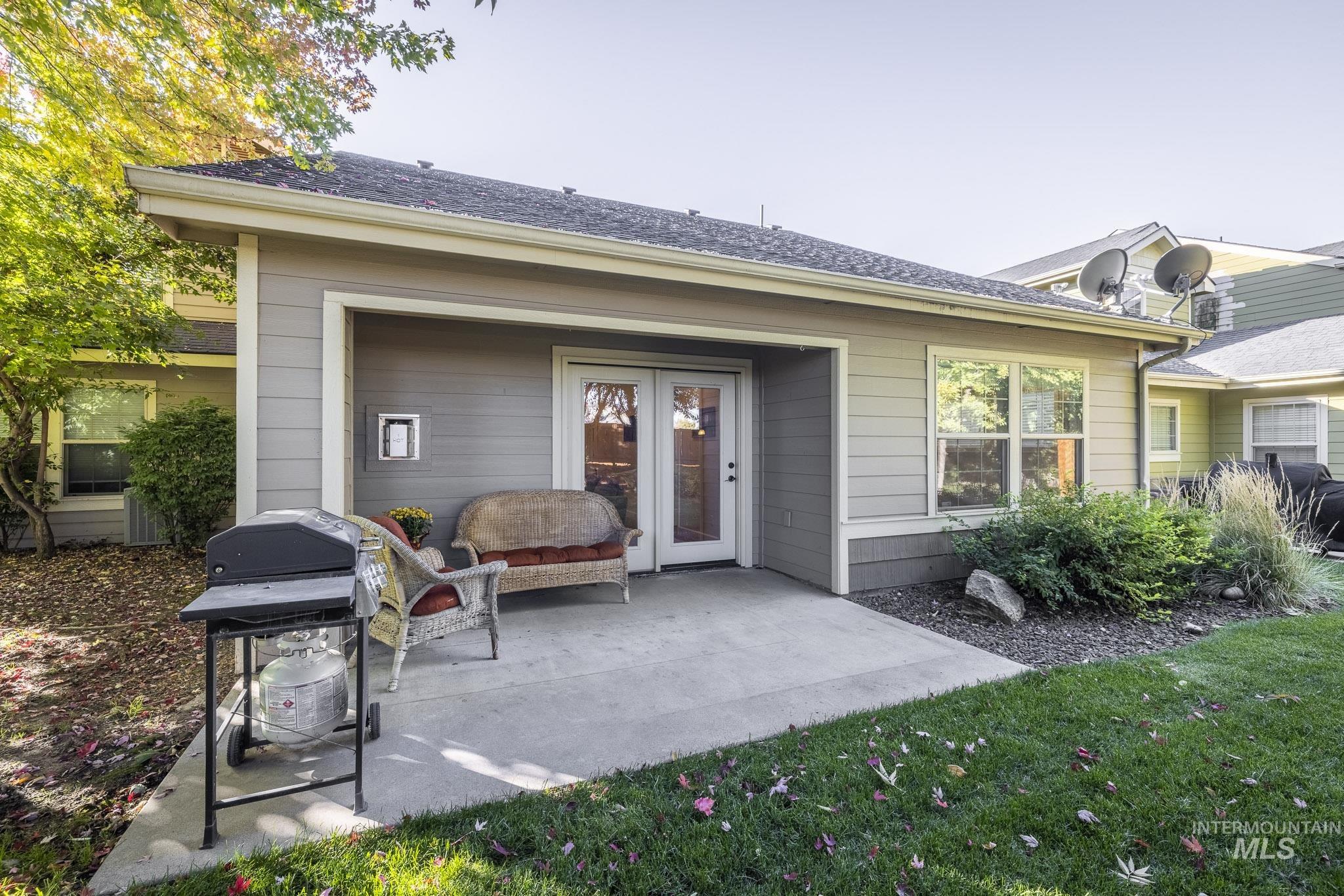 Rear view of property with a patio area, a lawn, and roof with shingles