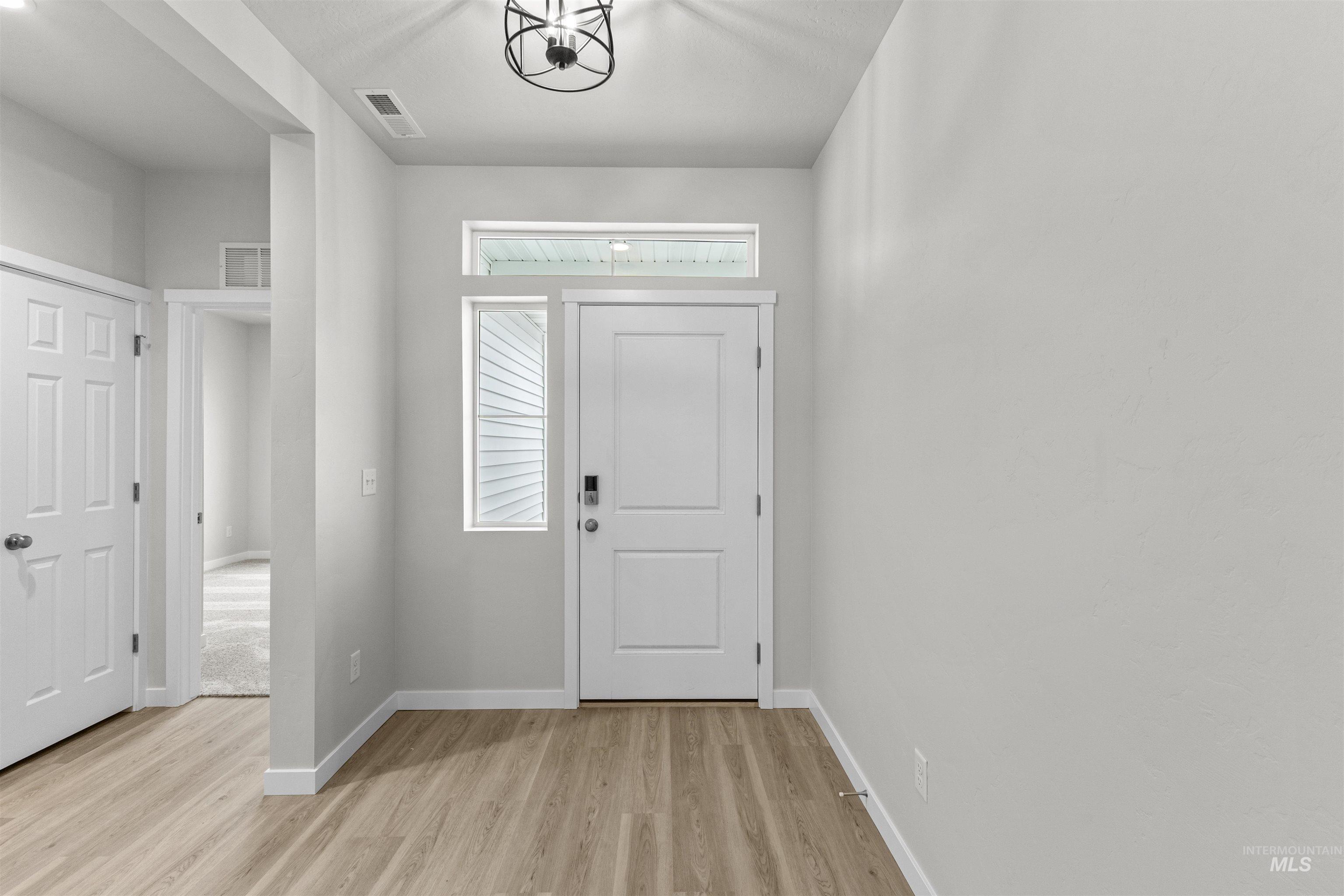 Entrance foyer featuring baseboards and light wood-style floors