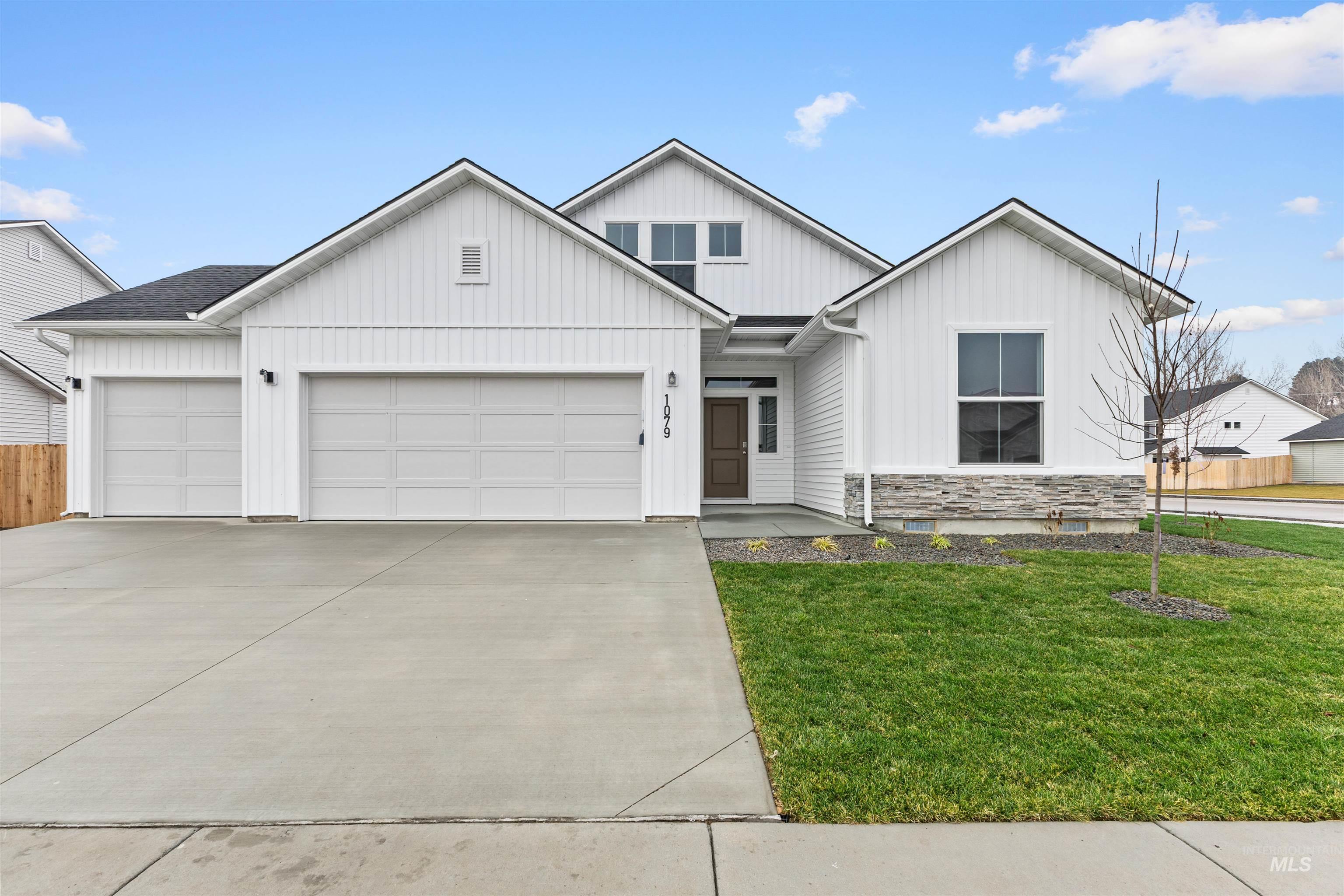 Modern farmhouse style home with driveway, an attached garage, and board and batten siding