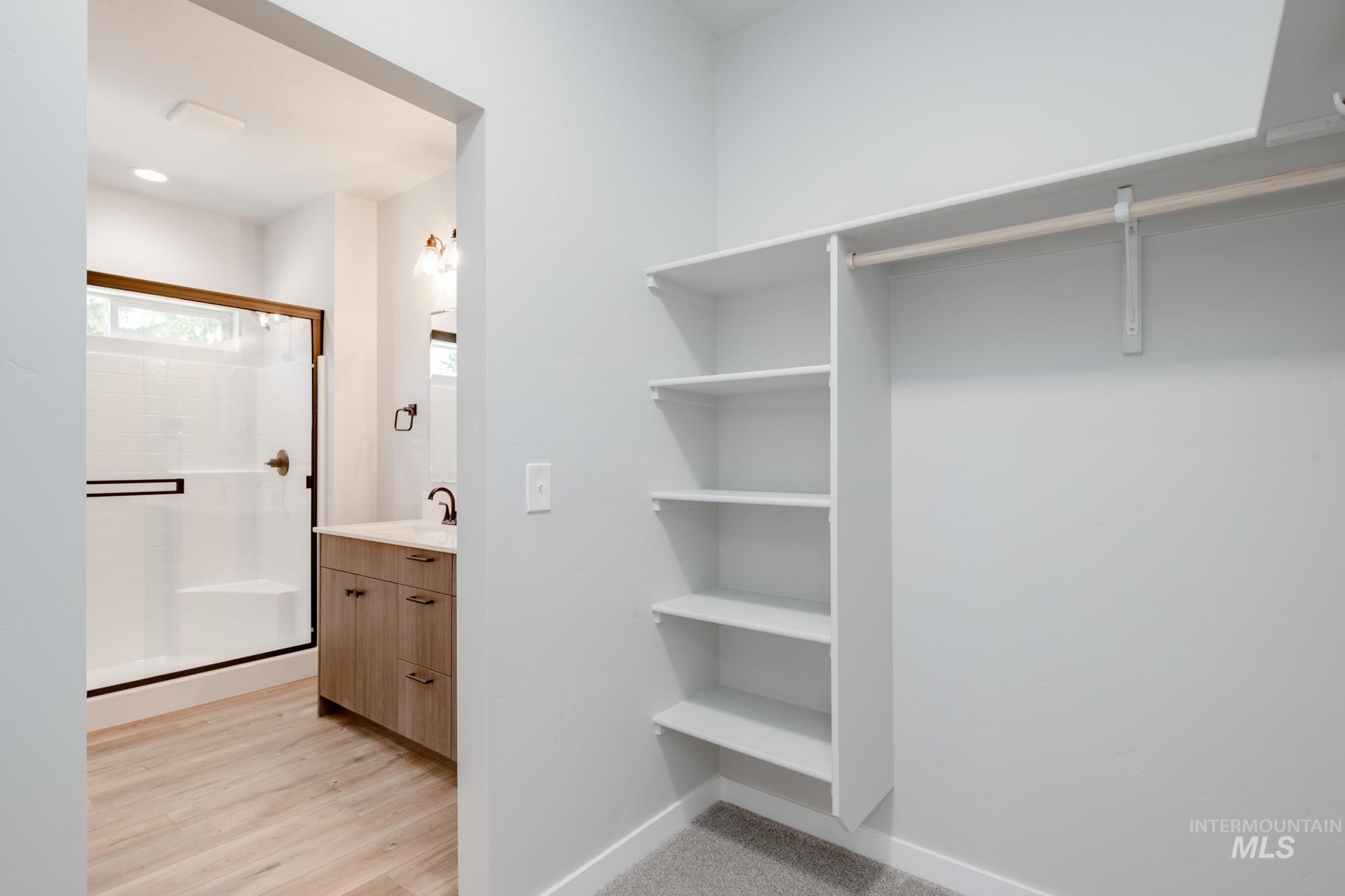 Walk in closet with a sink and light wood-style flooring