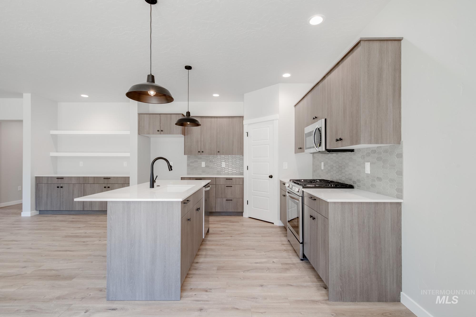 Kitchen with stainless steel appliances, light wood-style flooring, tasteful backsplash, modern cabinets, and recessed lighting