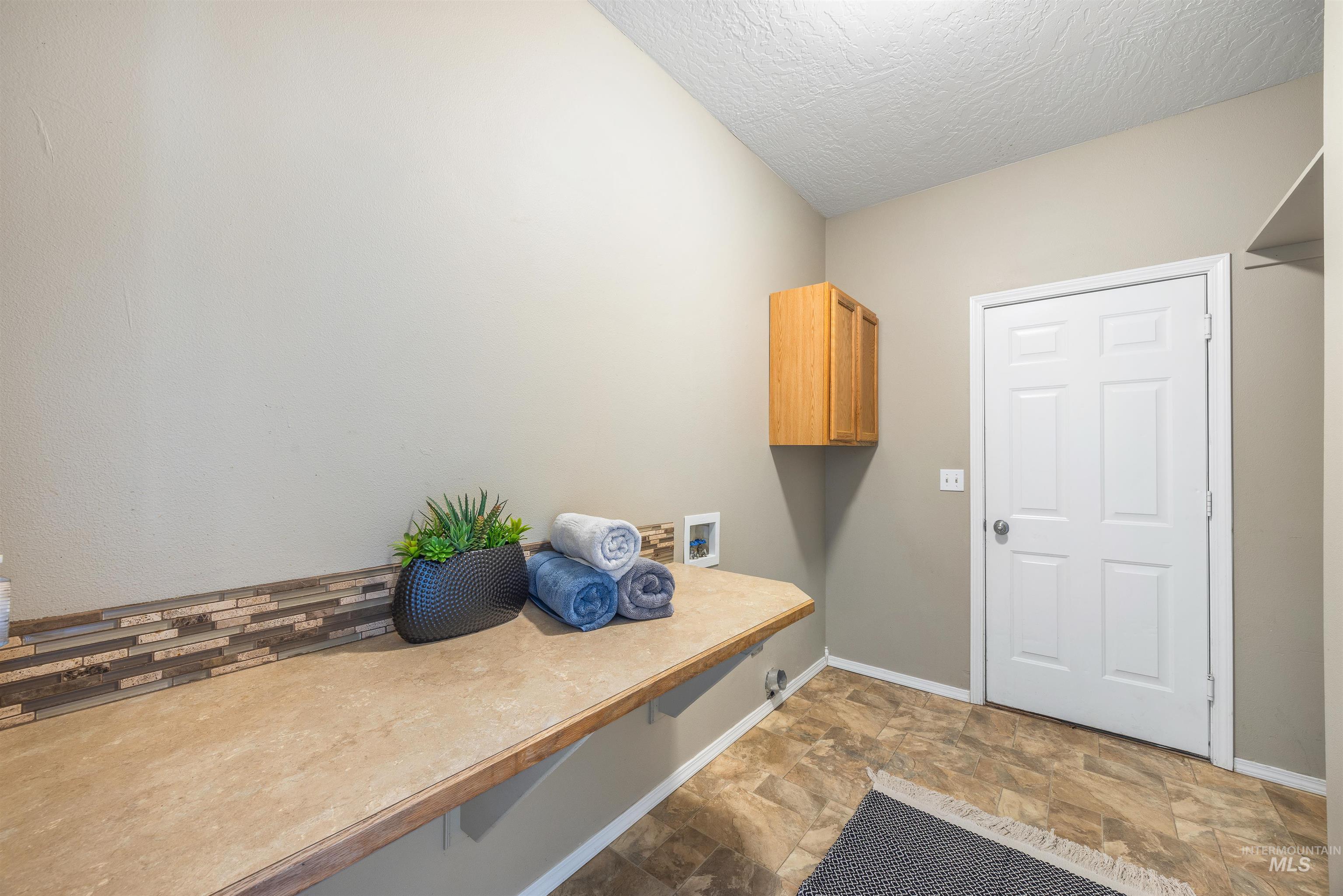 Mudroom with stone finish flooring and a textured ceiling