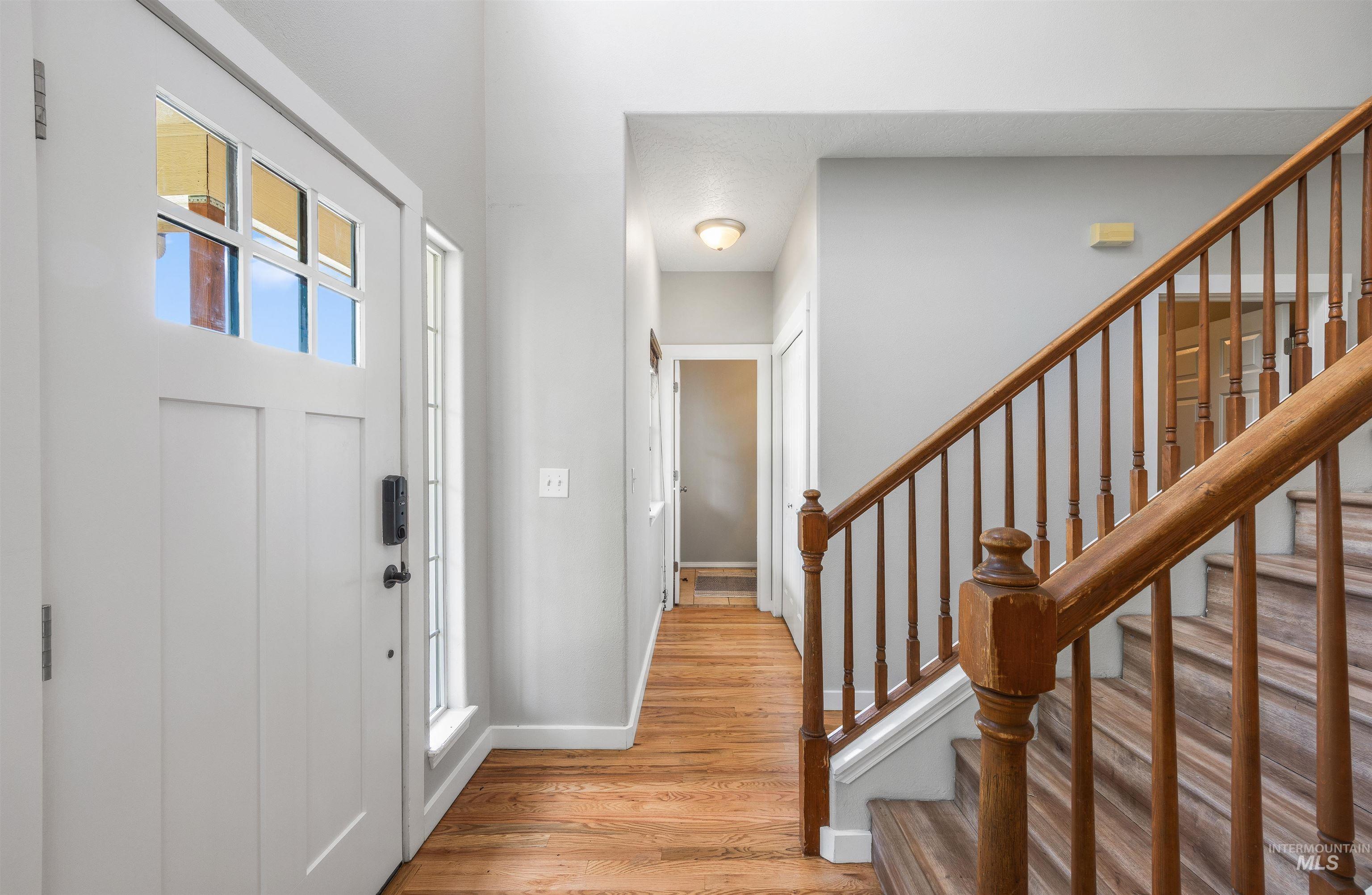 Foyer with light wood-type flooring and stairs