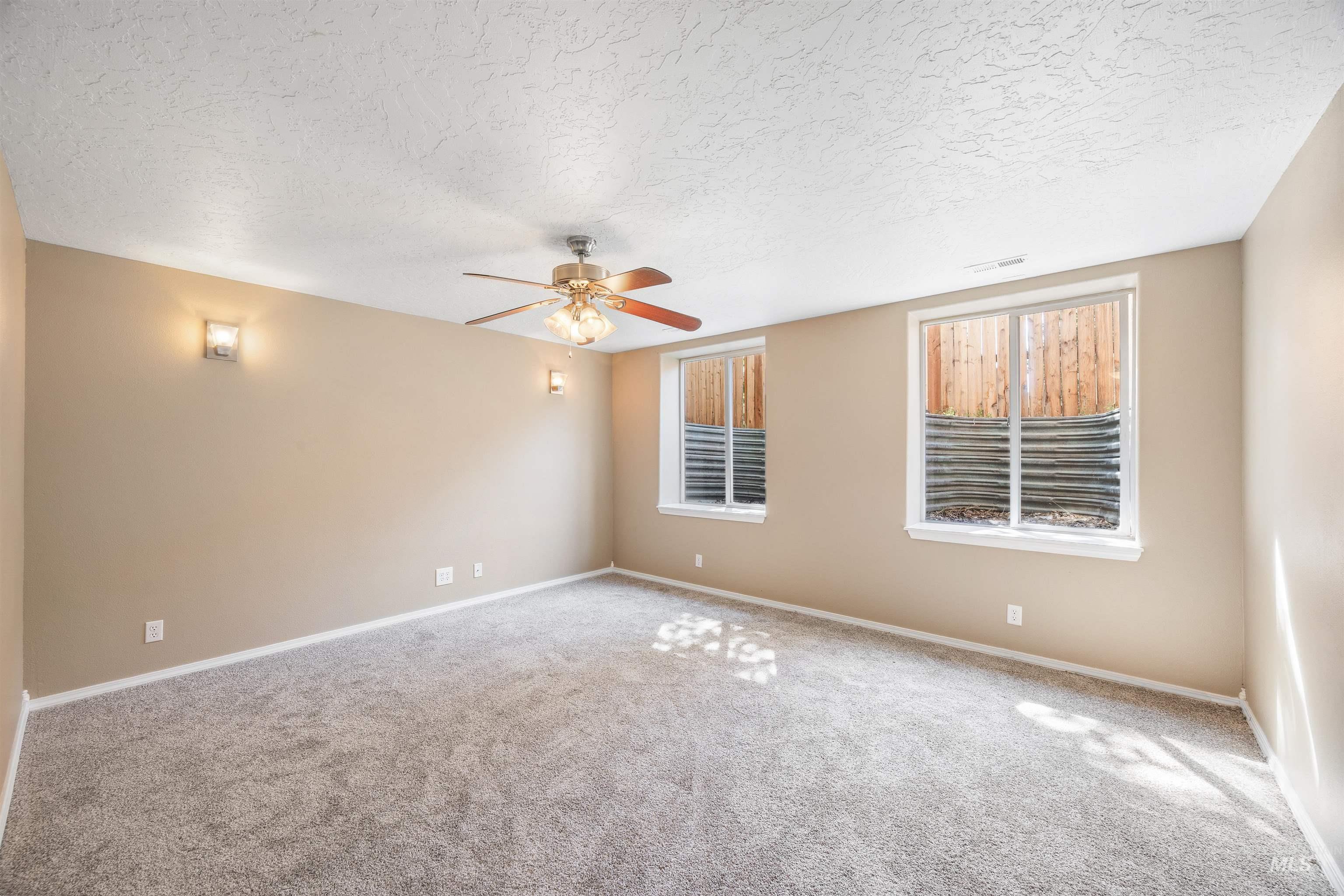 Spare room with carpet flooring, ceiling fan, and a textured ceiling
