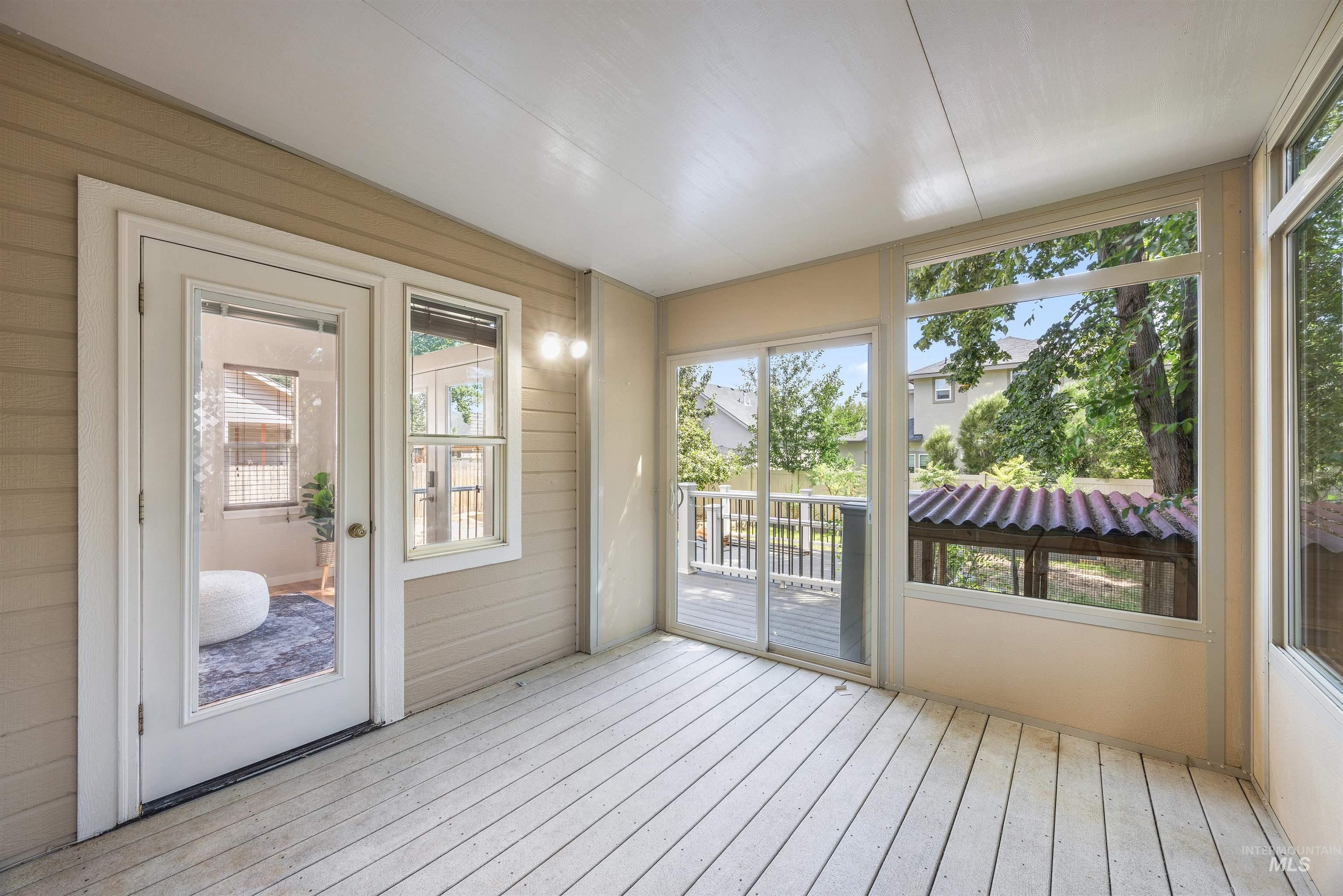 Unfurnished sunroom with wooden walls and wood-type flooring