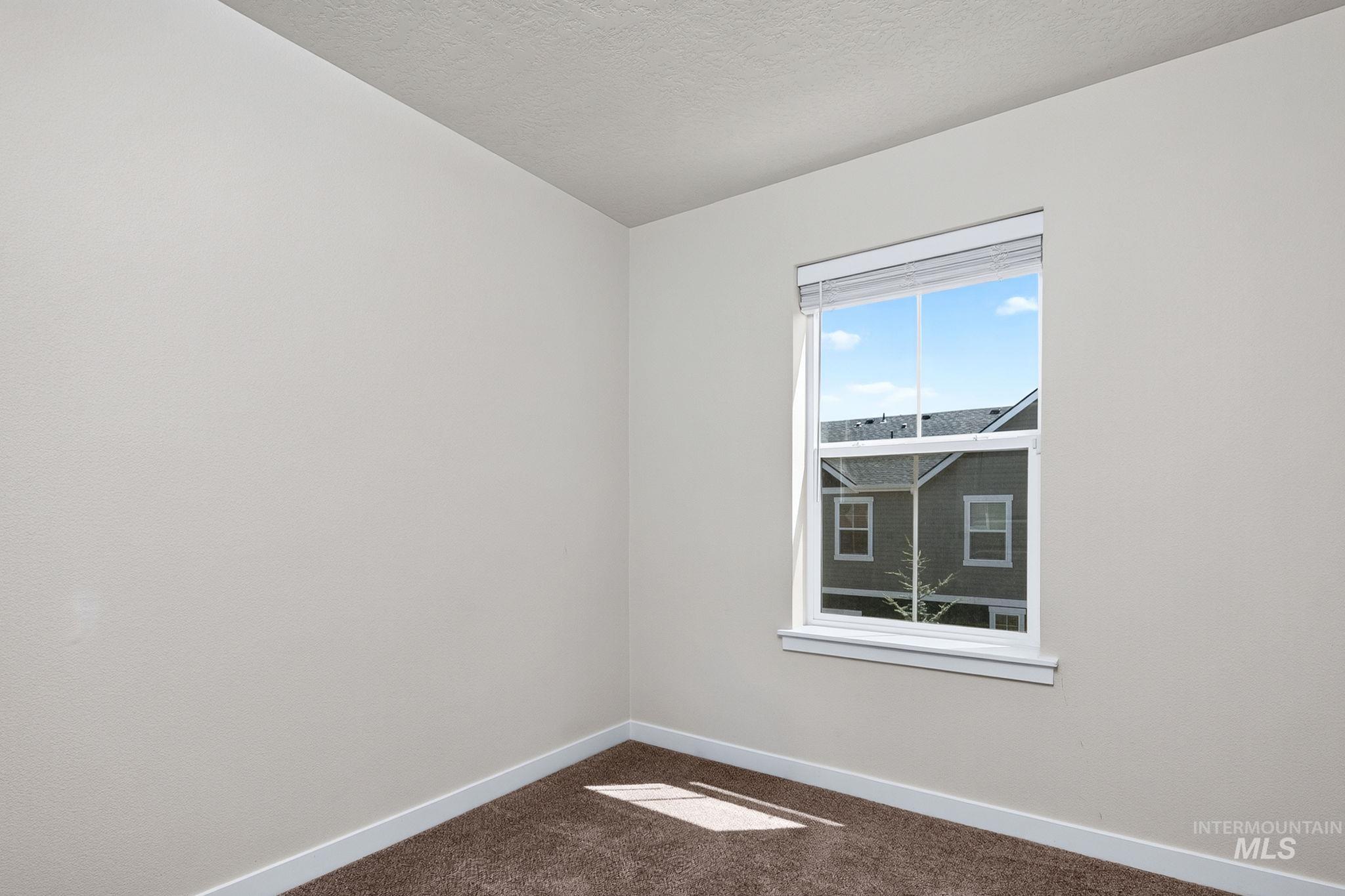 Neutral-toned walls complement the brown carpet flooring and white trim