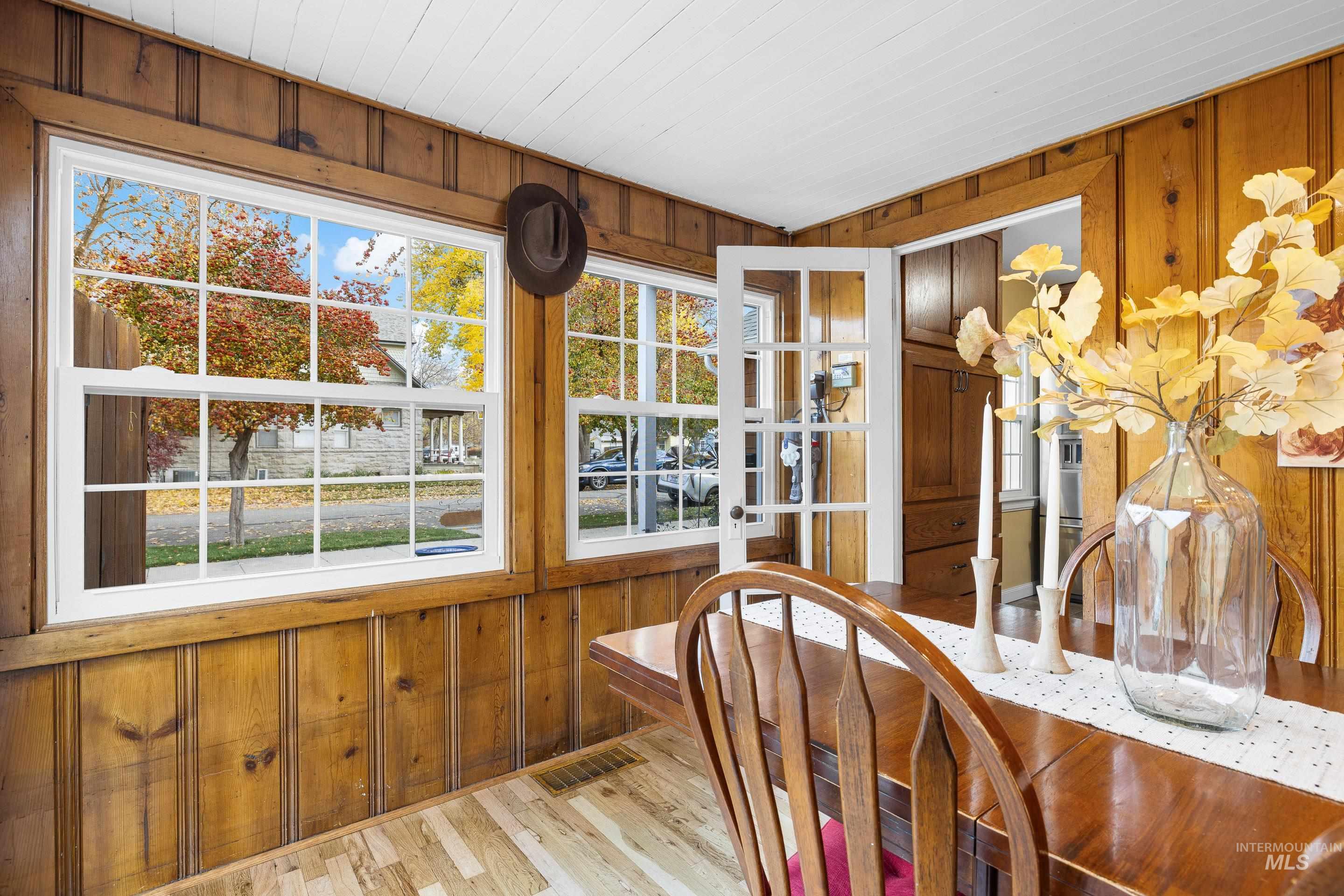 Dining space with wood walls and light wood finished floors