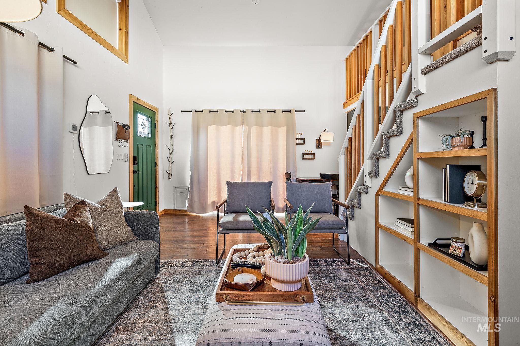 Living area with wood finished floors, stairs, and a towering ceiling