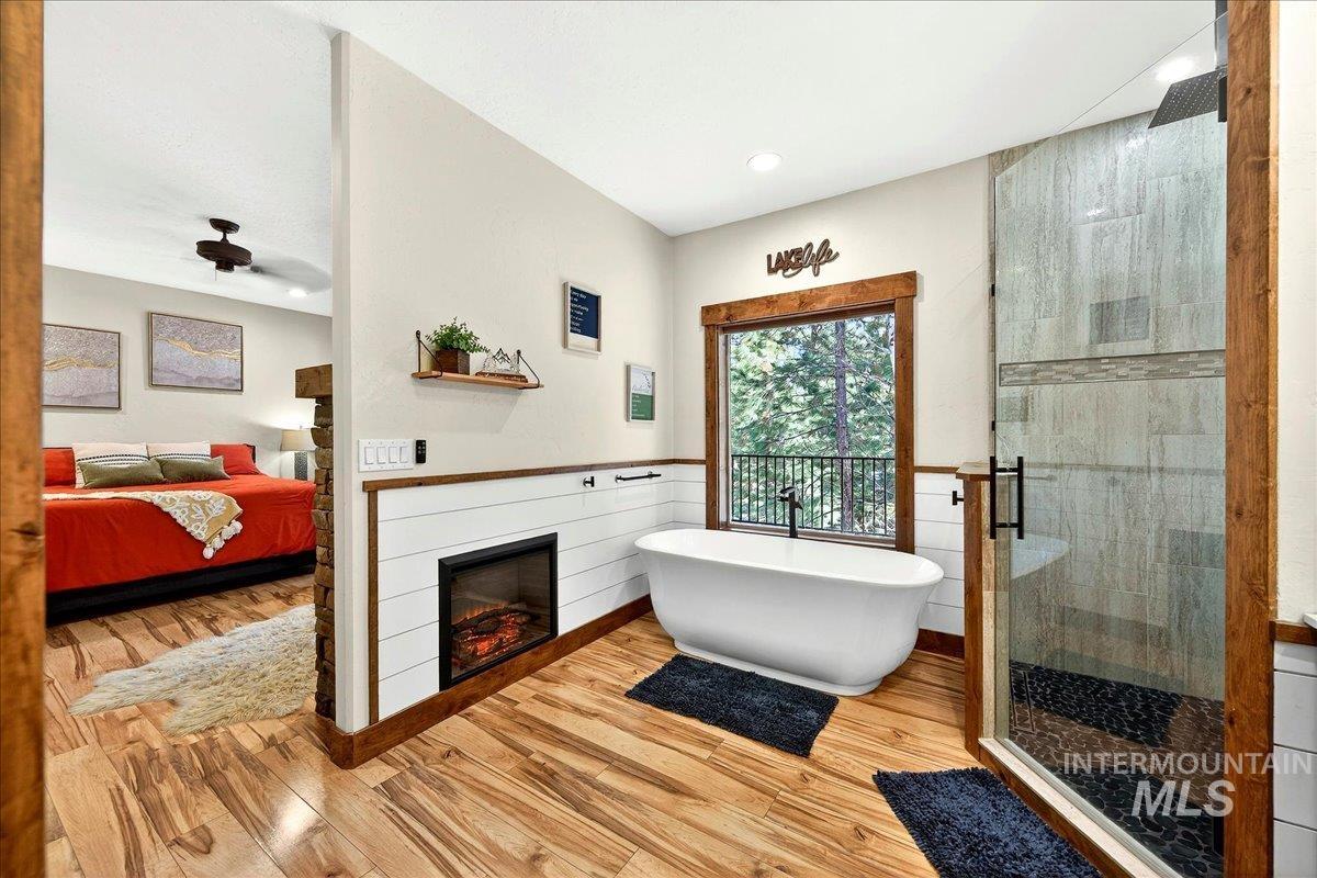 Ensuite bathroom with tile shower, a soaking tub, and fireplace