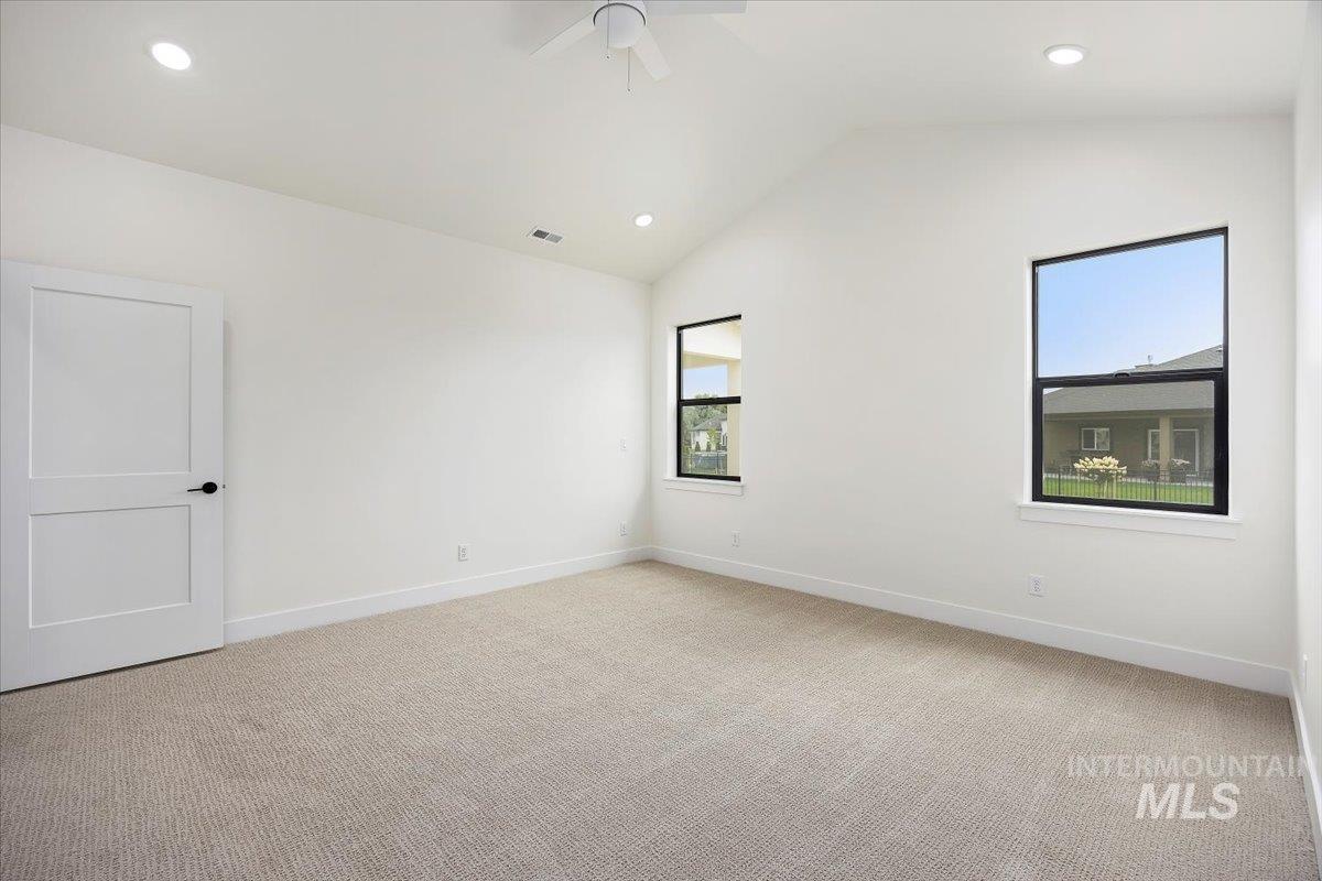 Spare room featuring light carpet, lofted ceiling, recessed lighting, and ceiling fan