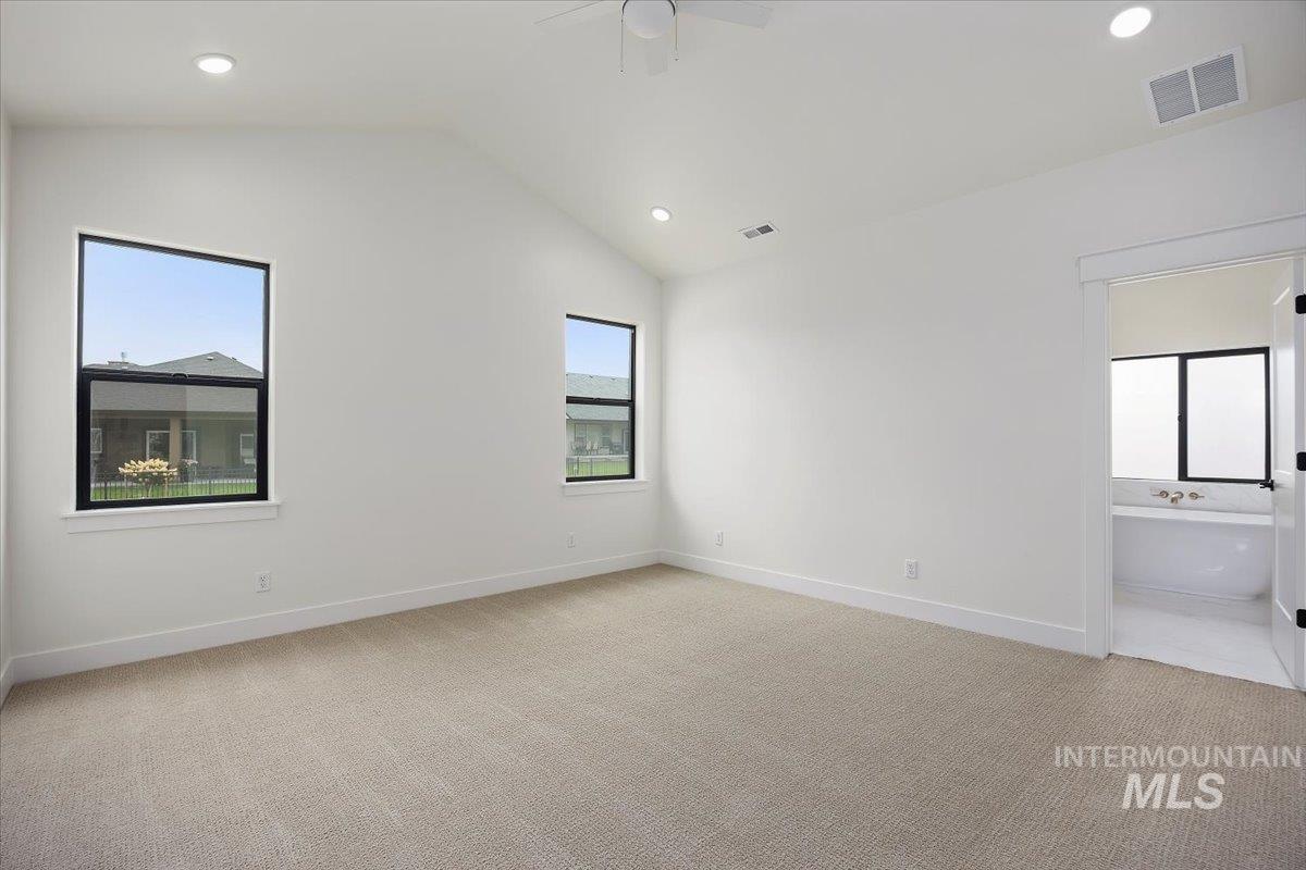 Unfurnished bedroom with recessed lighting, light colored carpet, vaulted ceiling, ceiling fan, and ensuite bathroom