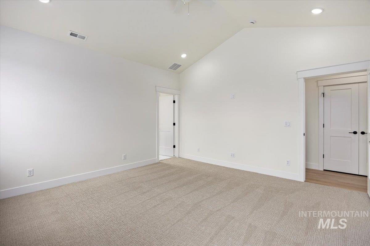 Empty room featuring light colored carpet, recessed lighting, a ceiling fan, and high vaulted ceiling