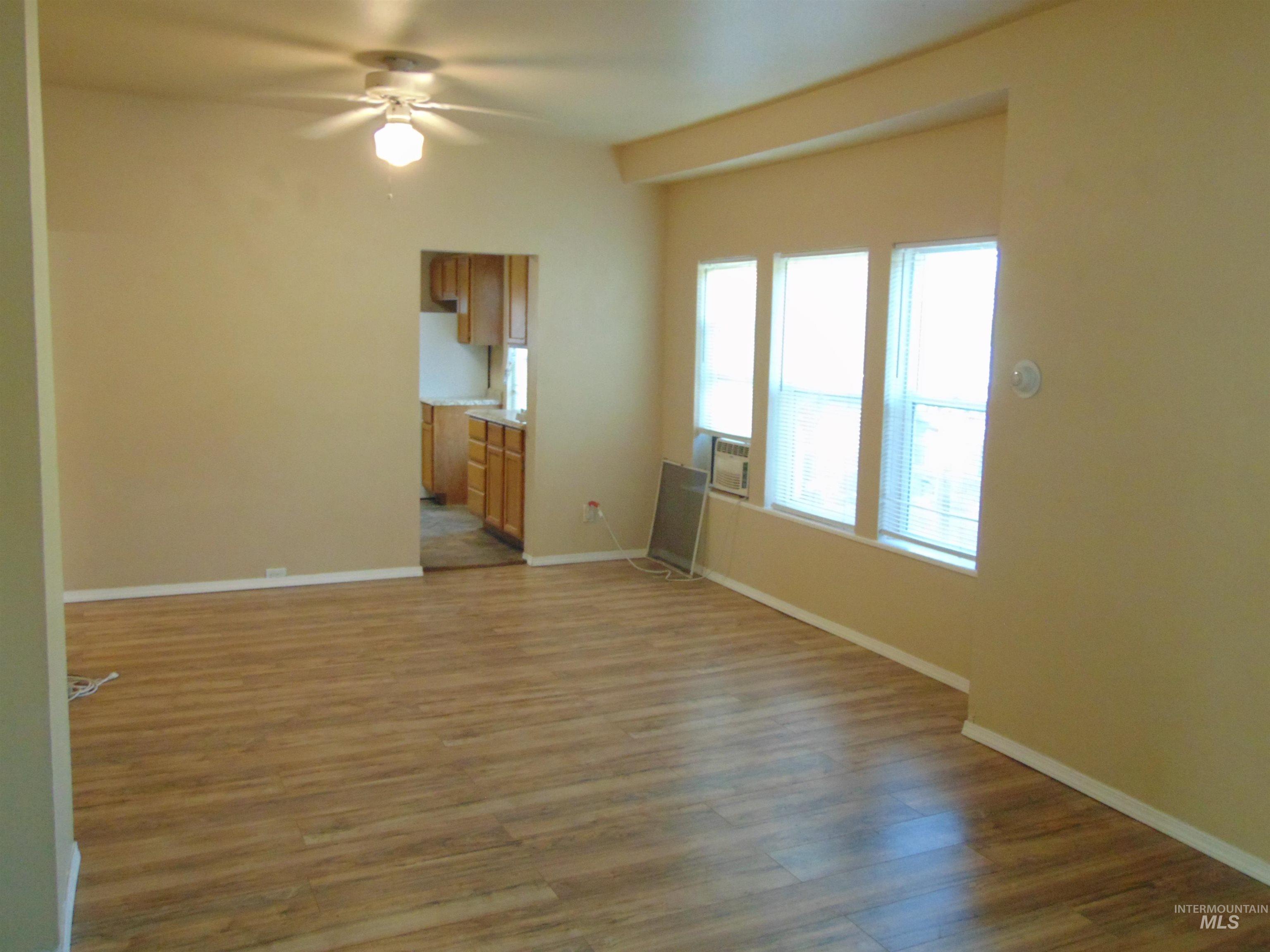 Unfurnished living room featuring light wood finished floors and a ceiling fan