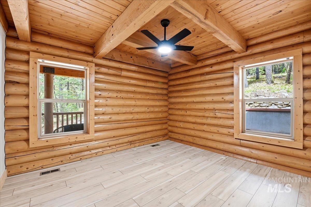 Log construction interior featuring exposed wood beams and wood-finish ceiling