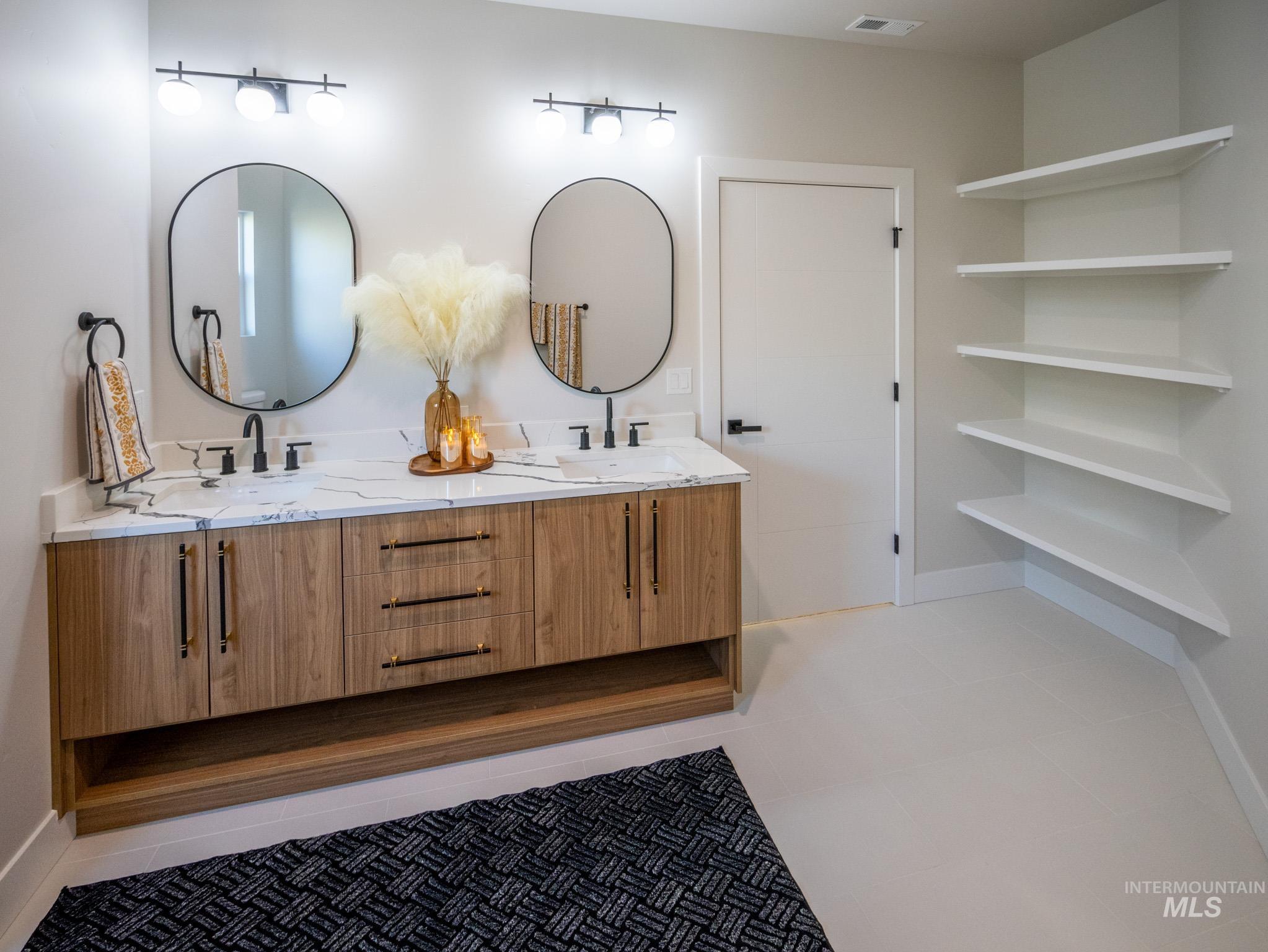 Full bathroom with double vanity and light tile patterned floors