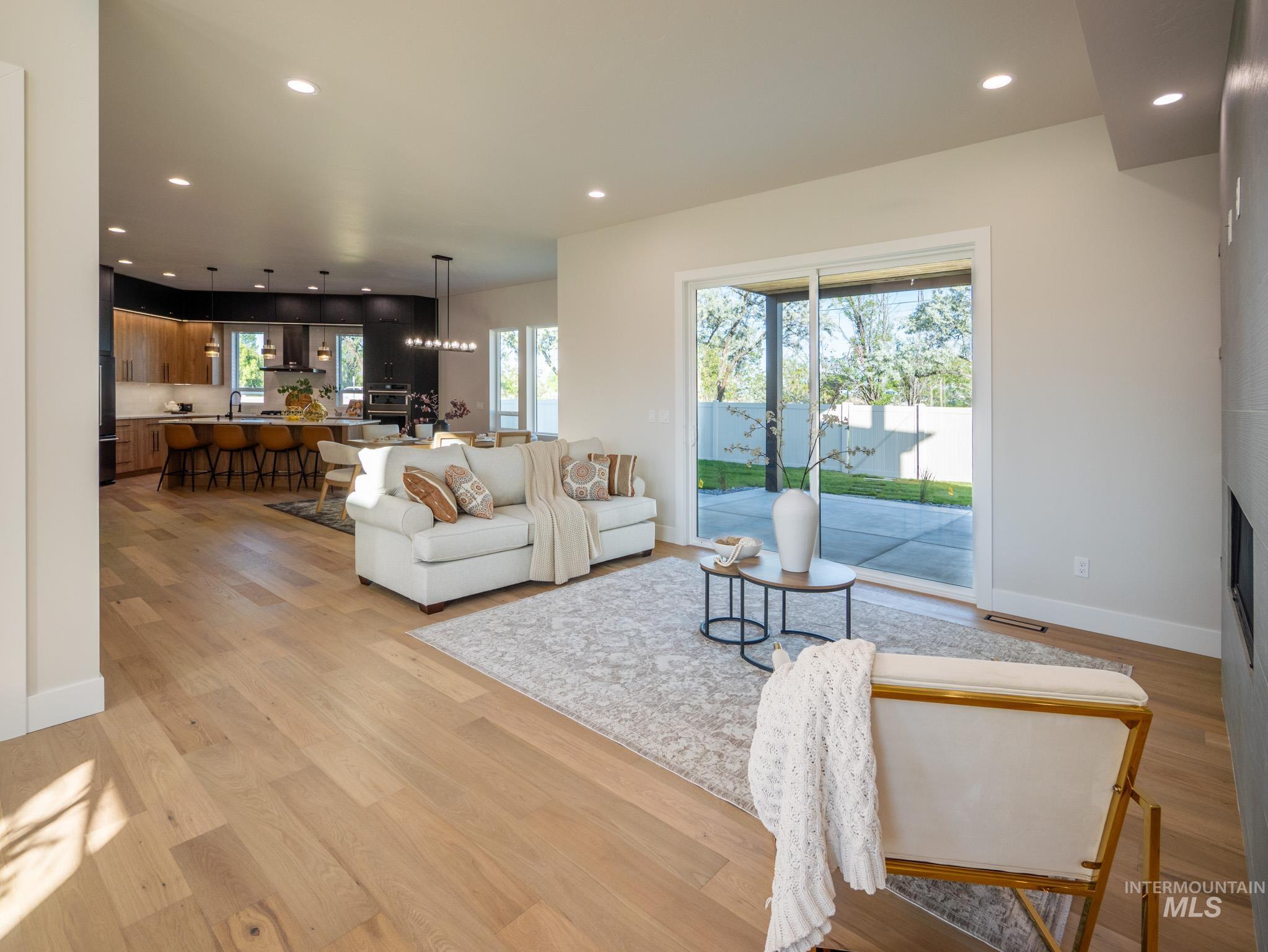 Living area with recessed lighting, a chandelier, and light wood-style flooring
