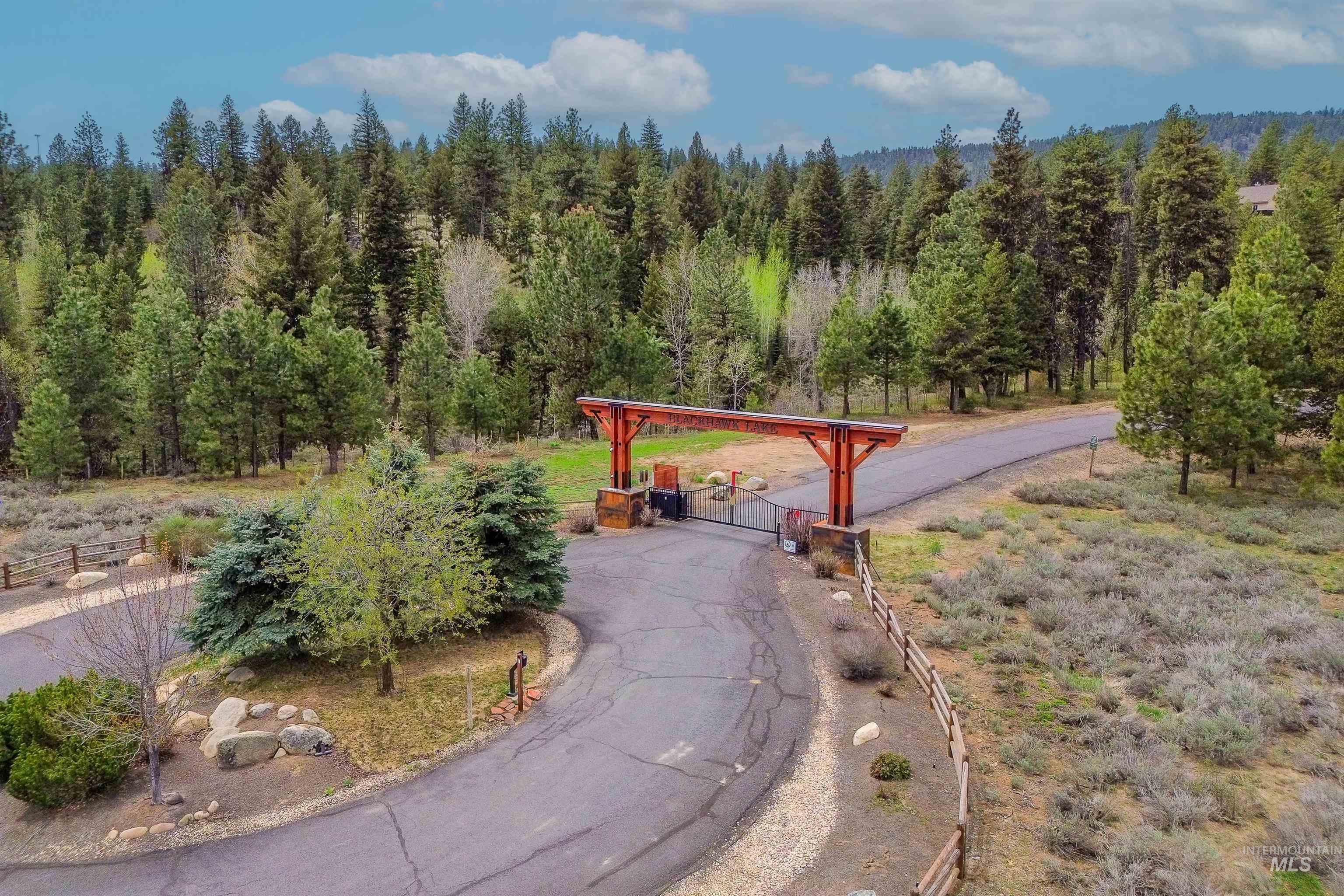 View of home's community with a wooded view and a gate