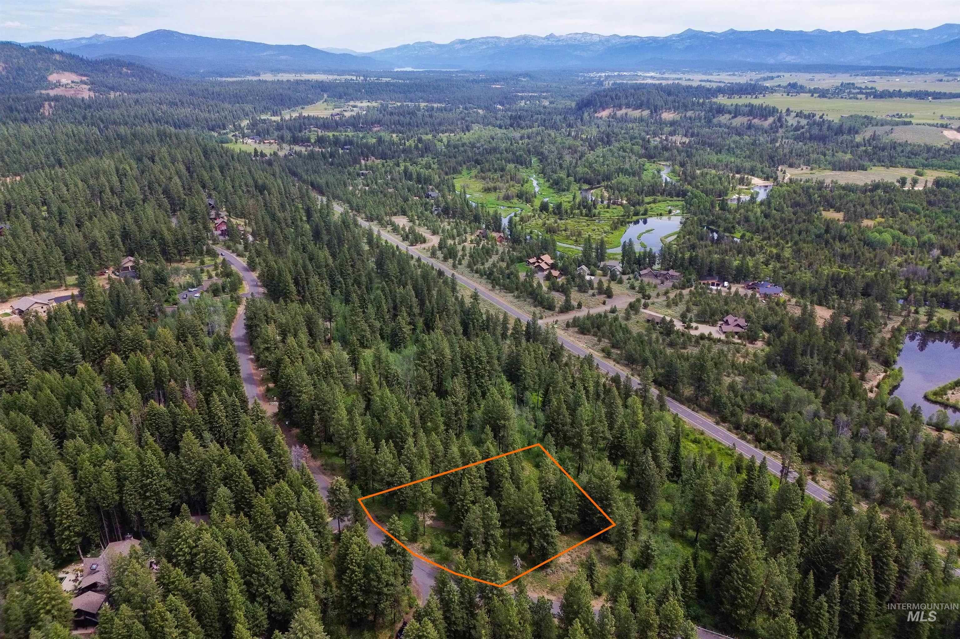 Aerial view of property and surrounding area featuring property parcel outlined and a water and mountain view