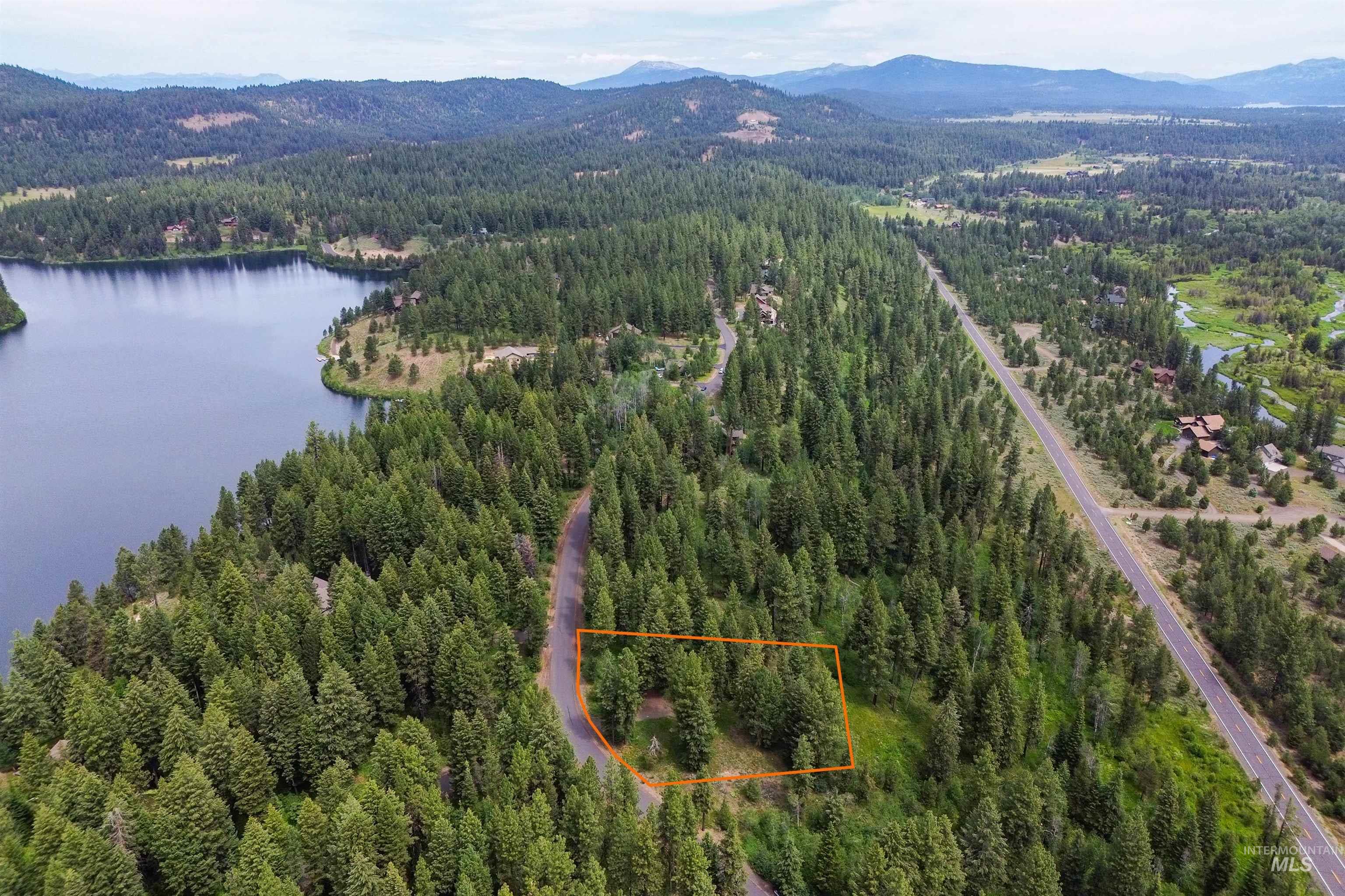 Aerial view of property's location with a water and mountain view and property boundaries highlighted