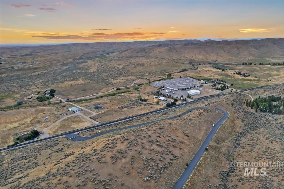 Aerial view of property's location featuring a mountain backdrop and rural landscape