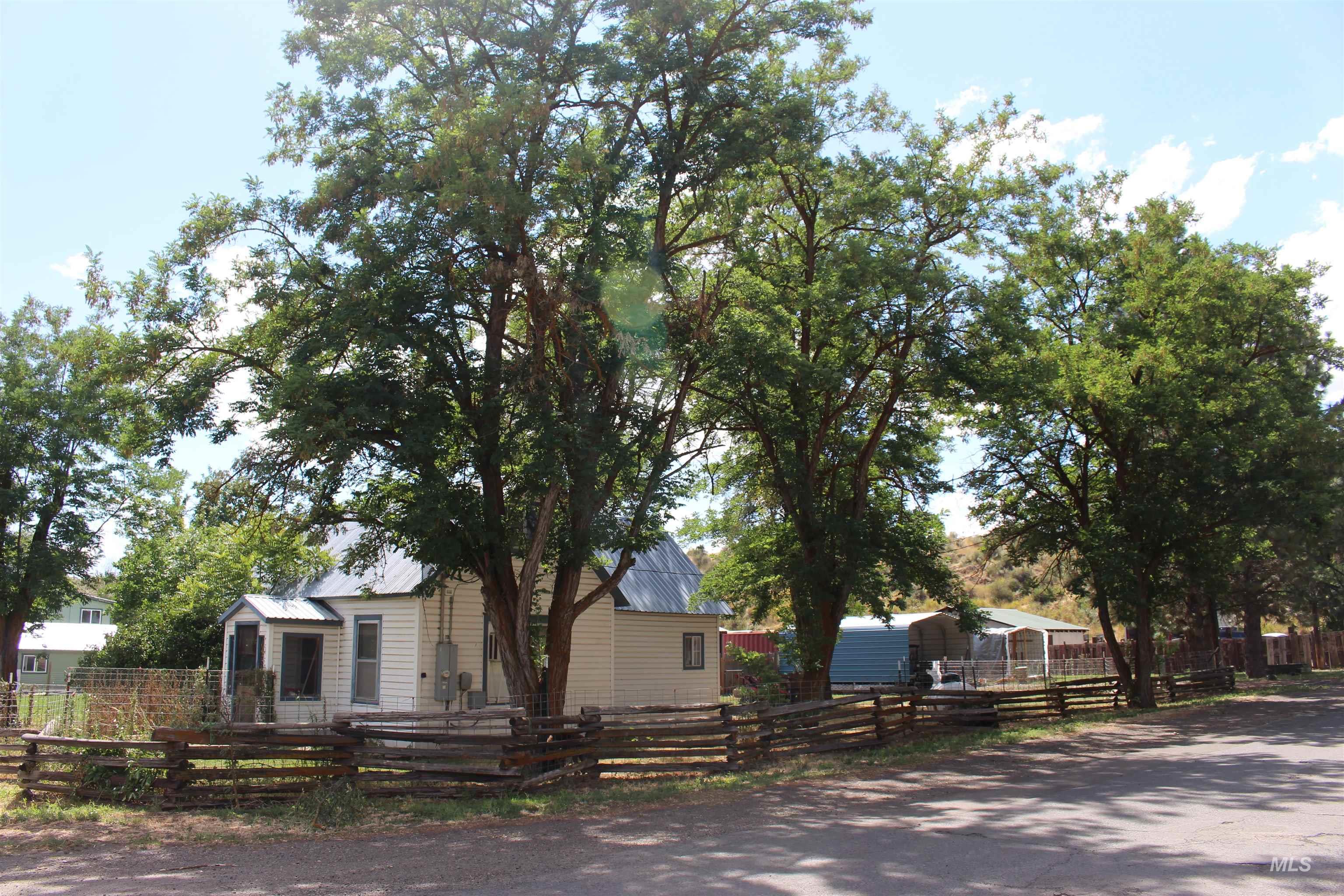 View of front of house featuring a fenced front yard and a metal roof