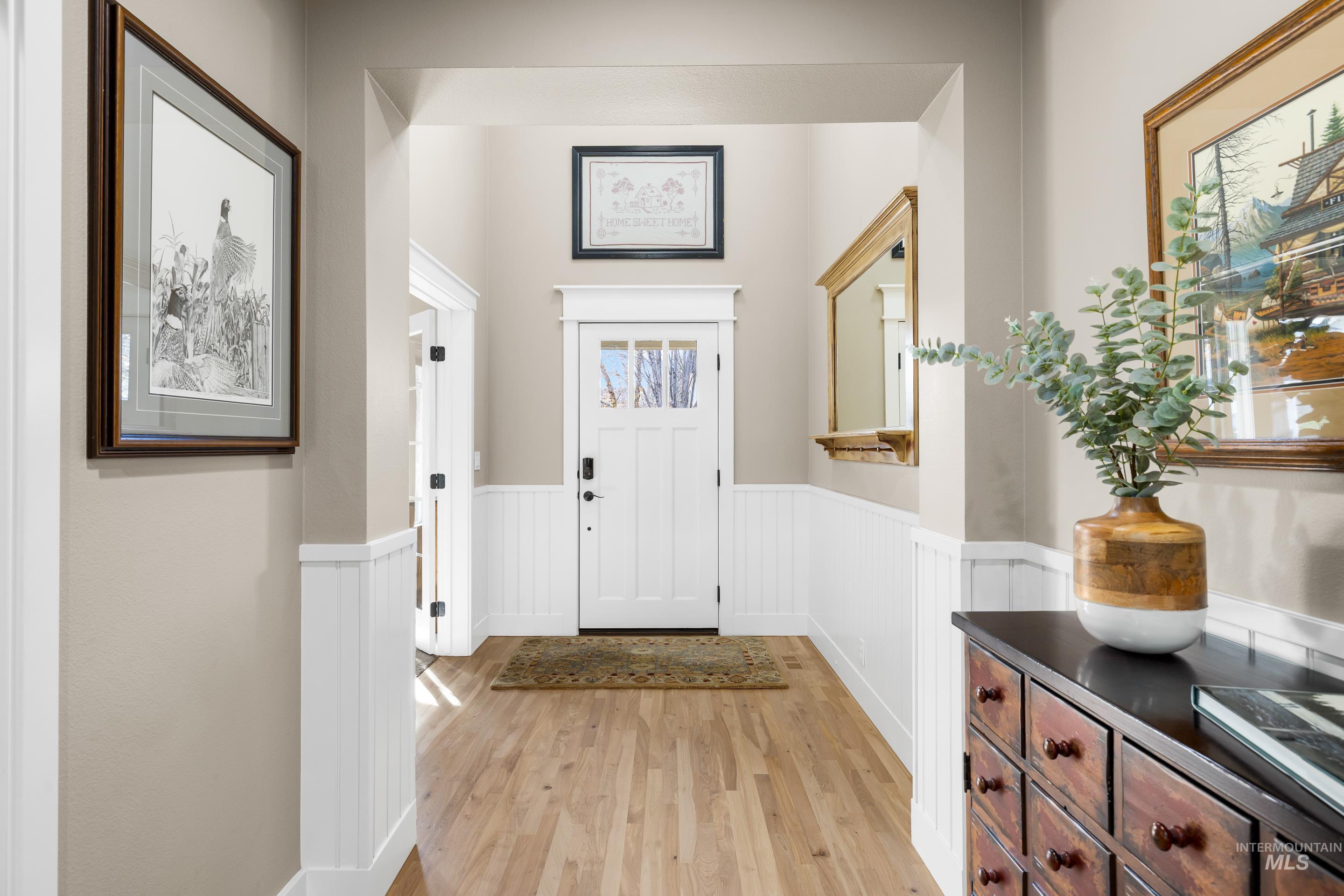 Foyer featuring light wood-type flooring and wainscoting