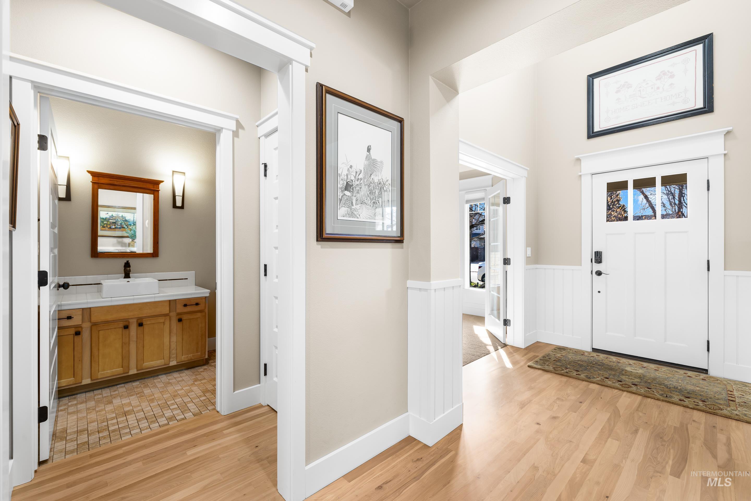 Entrance foyer featuring light wood finished floors and a wainscoted wall