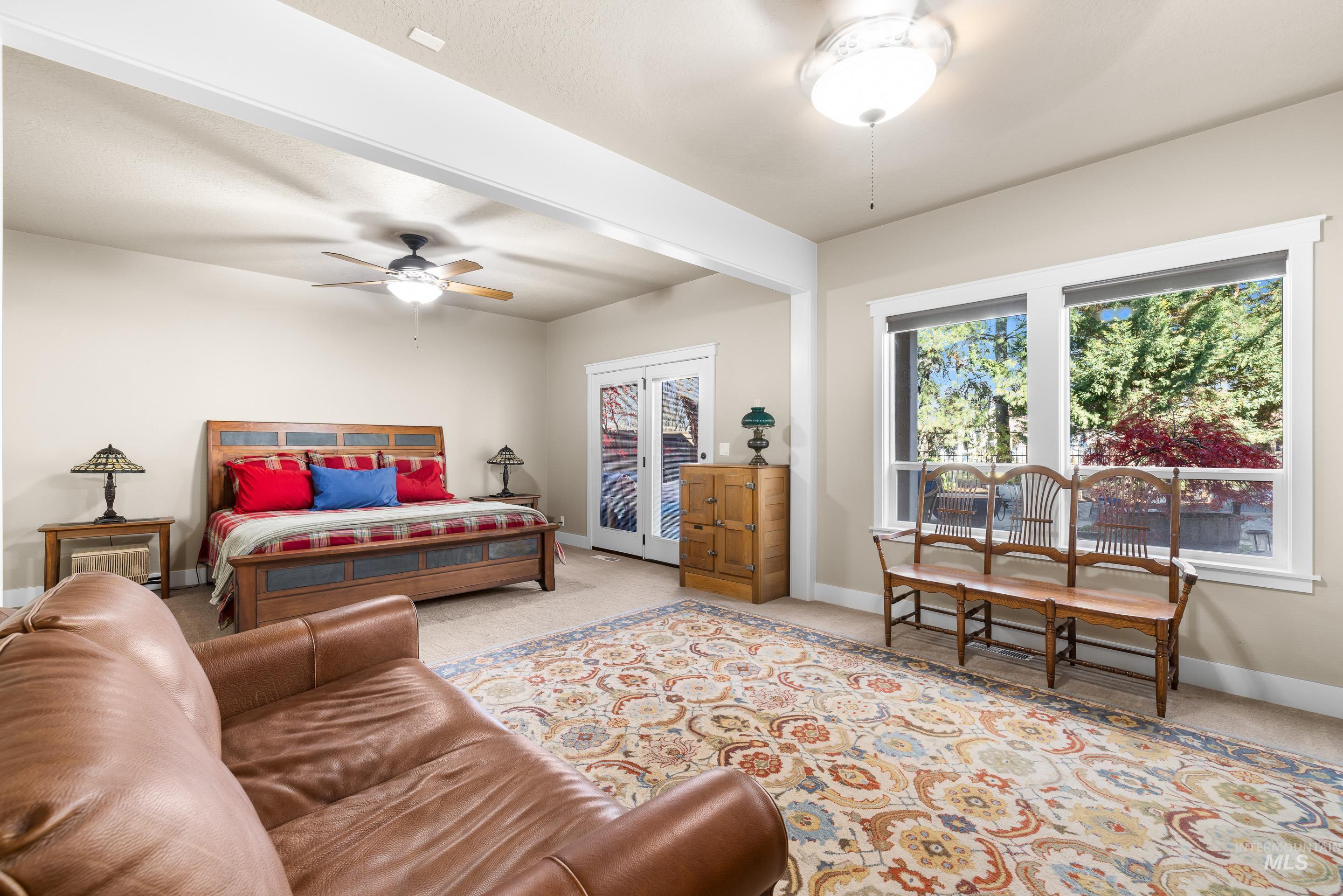Carpeted bedroom with access to exterior, beamed ceiling, and ceiling fan