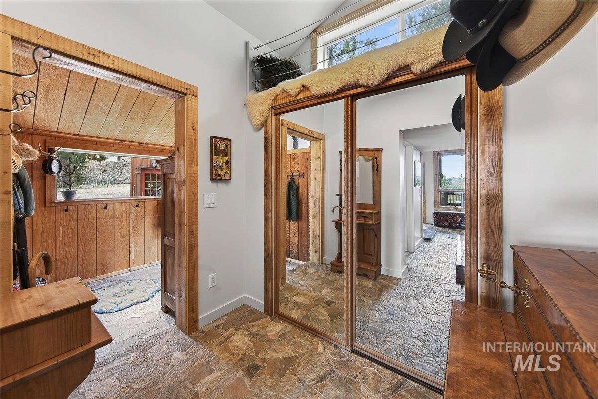 Bathroom with stone flooring, healthy amount of natural light, wood walls, a high ceiling, and vanity