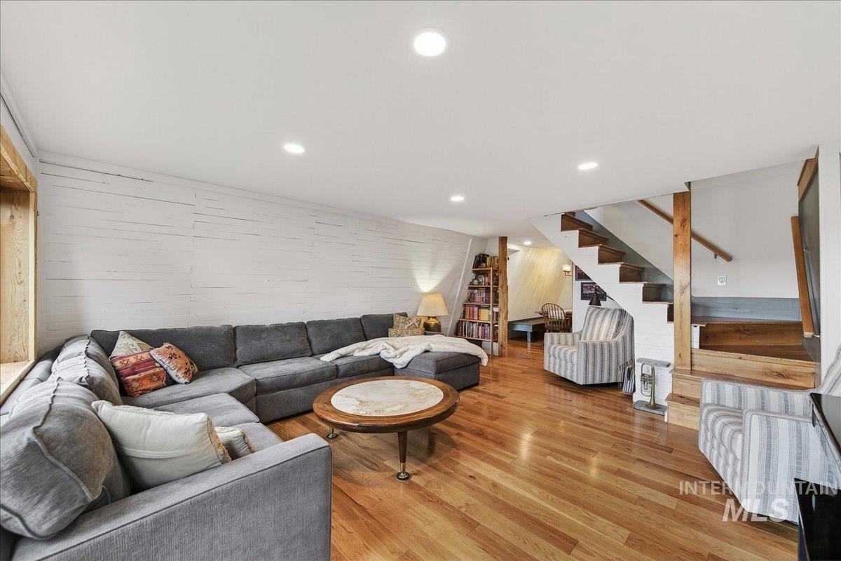 Living area with wood finished floors, recessed lighting, and wood walls
