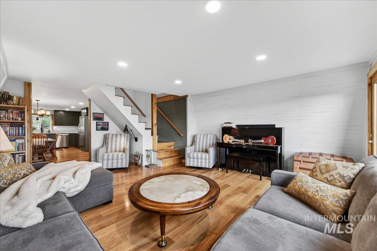 Living area with wood finished floors and suspended lighting