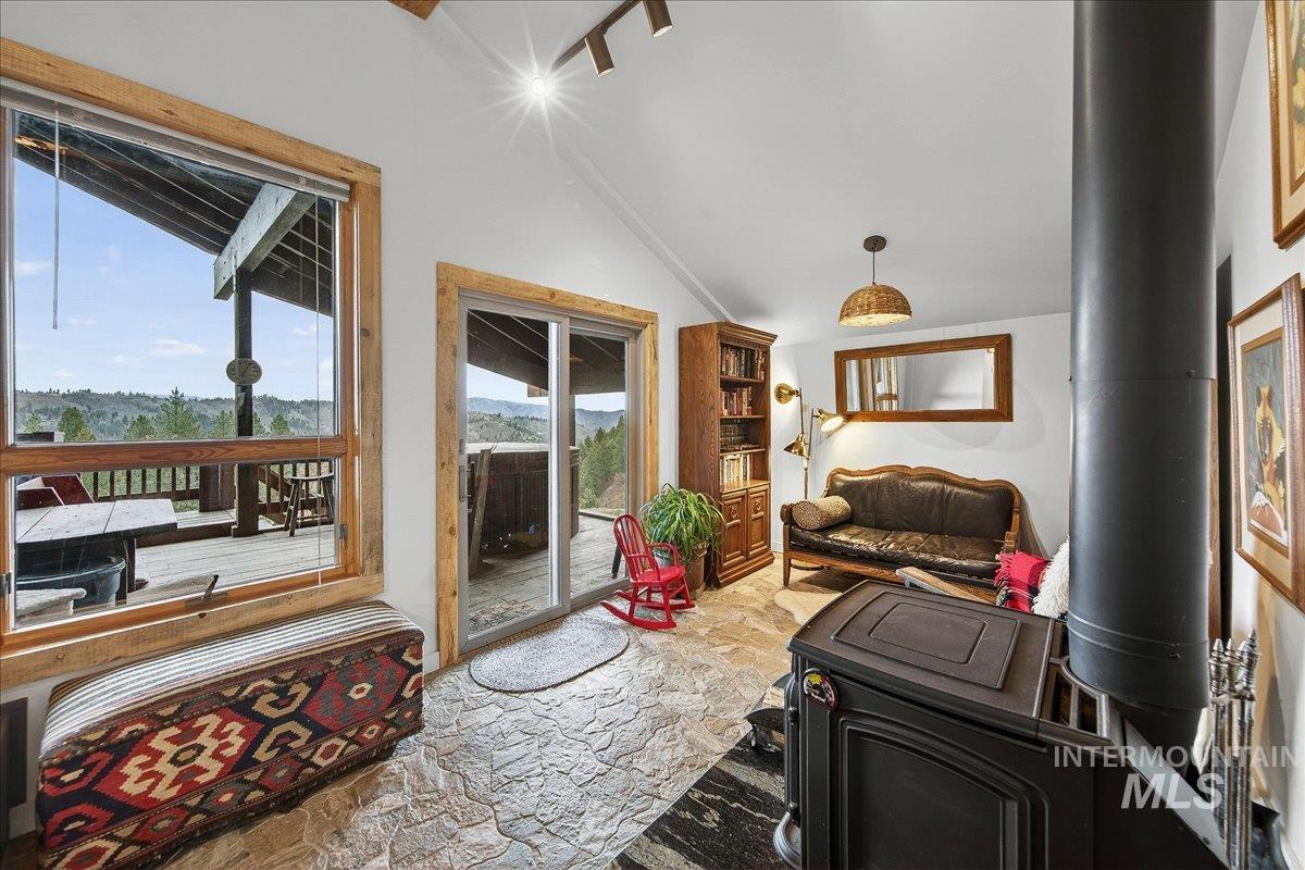 Living area with stone floors, plenty of natural light, and a wood stove