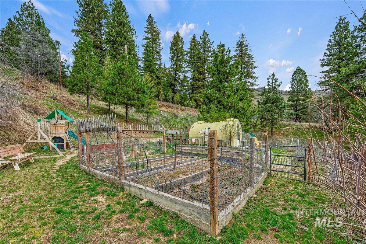 View of yard featuring a vegetable garden and a playground