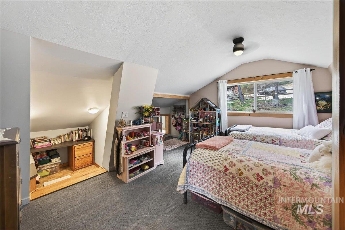Bedroom with dark carpet, a textured ceiling, and a ceiling fan