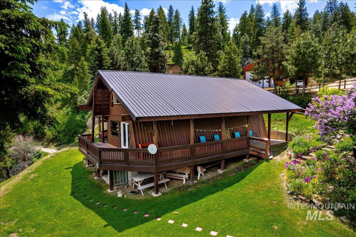 Back of house featuring a metal roof, a lawn, and a porch