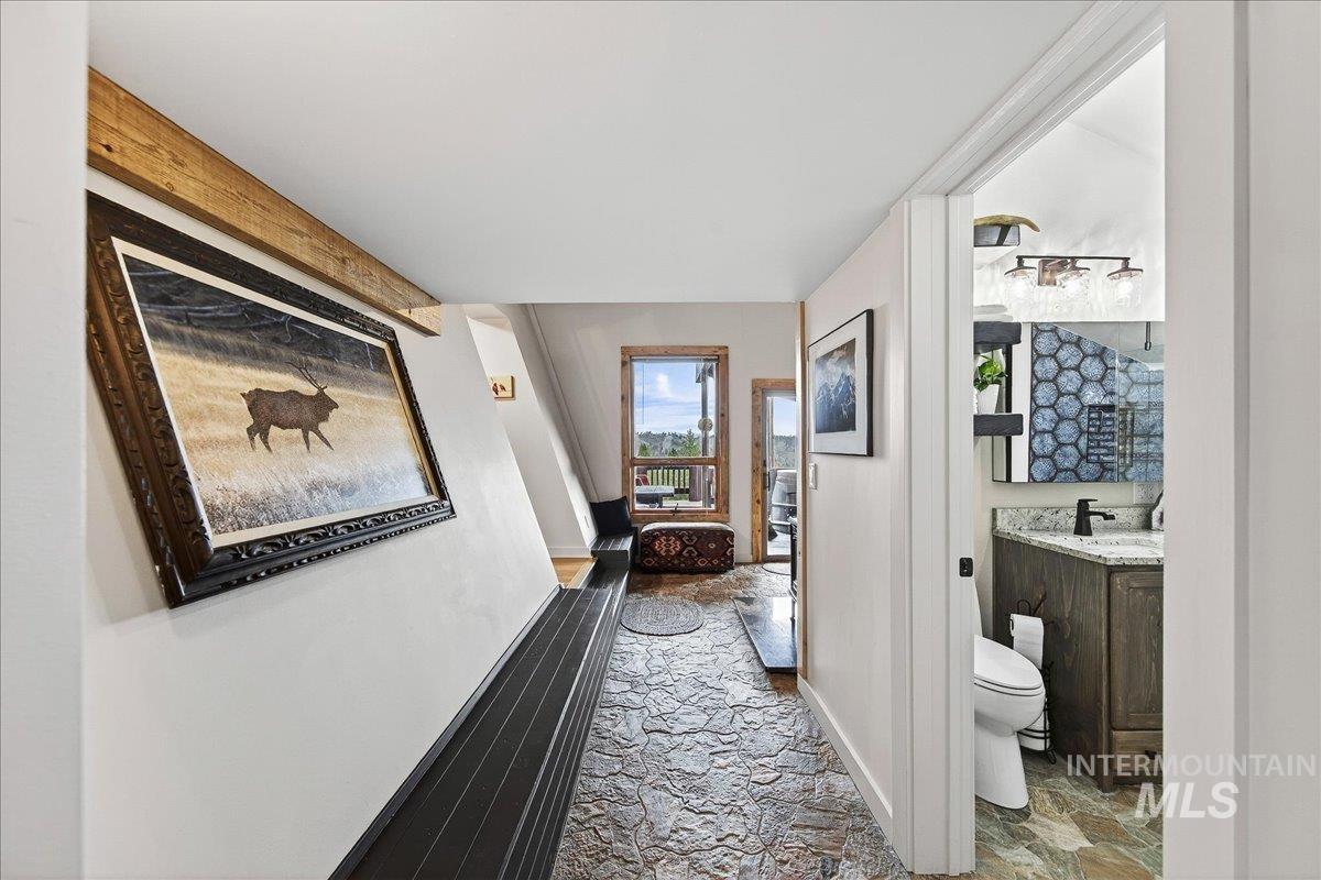 Hall with light stone finish flooring and baseboards