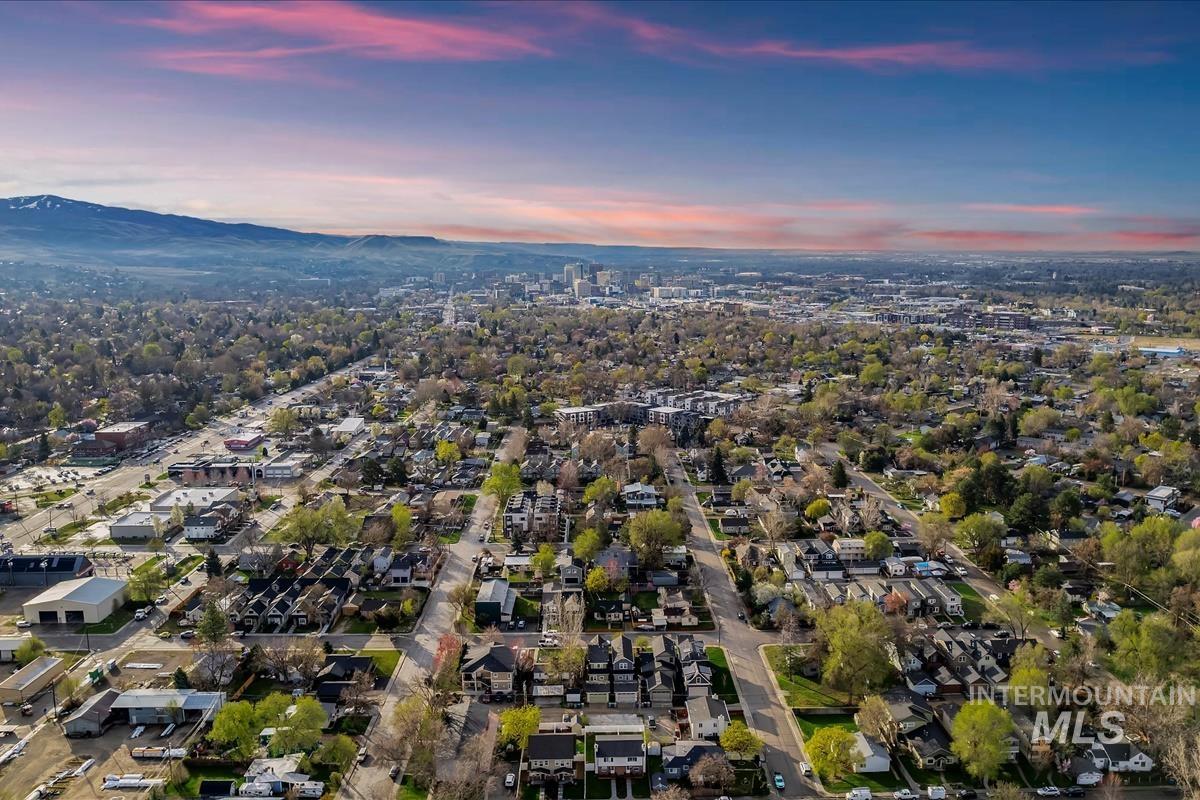 Aerial view of property and surrounding area featuring a mountainous background