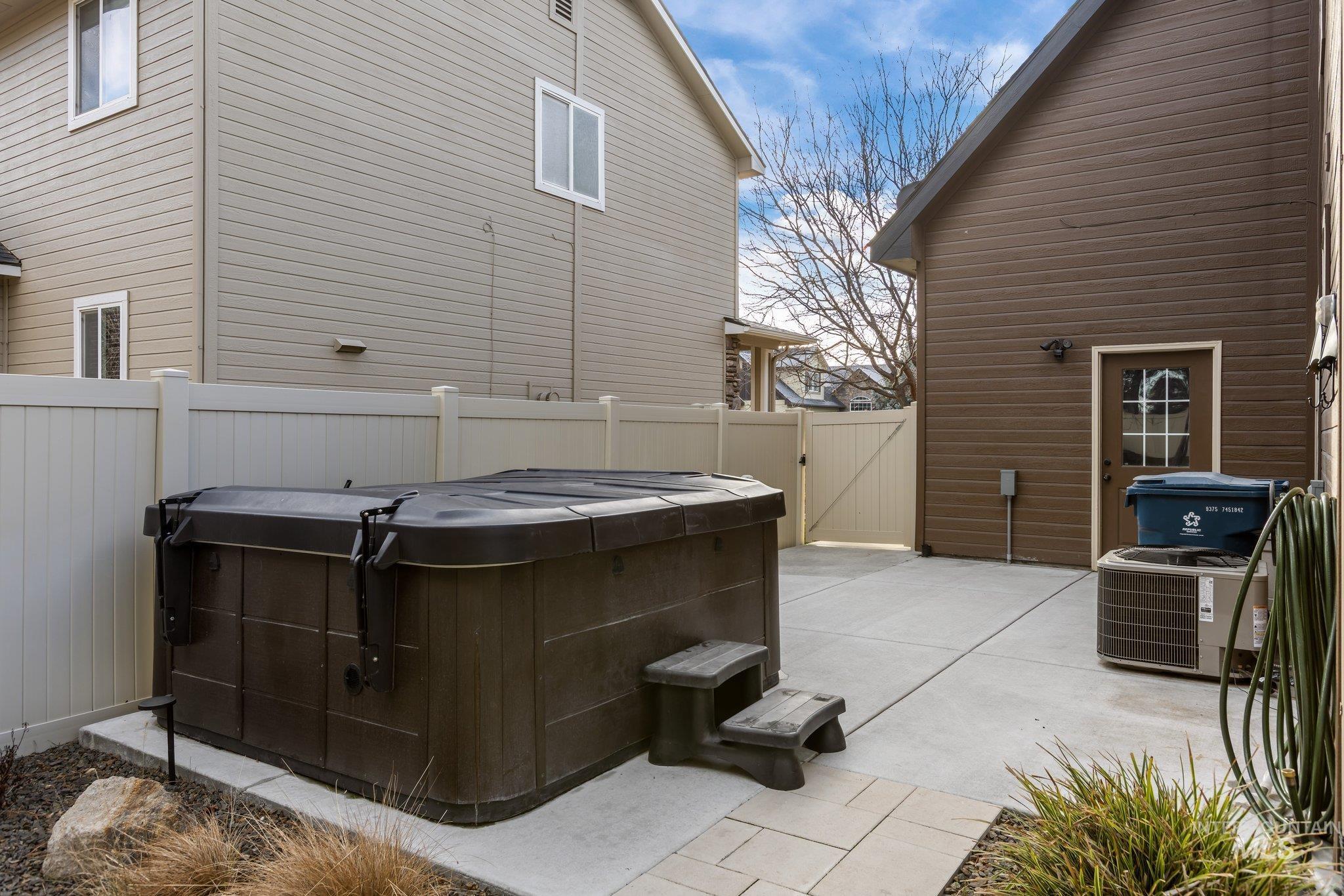 View of patio / terrace with a hot tub and a gate